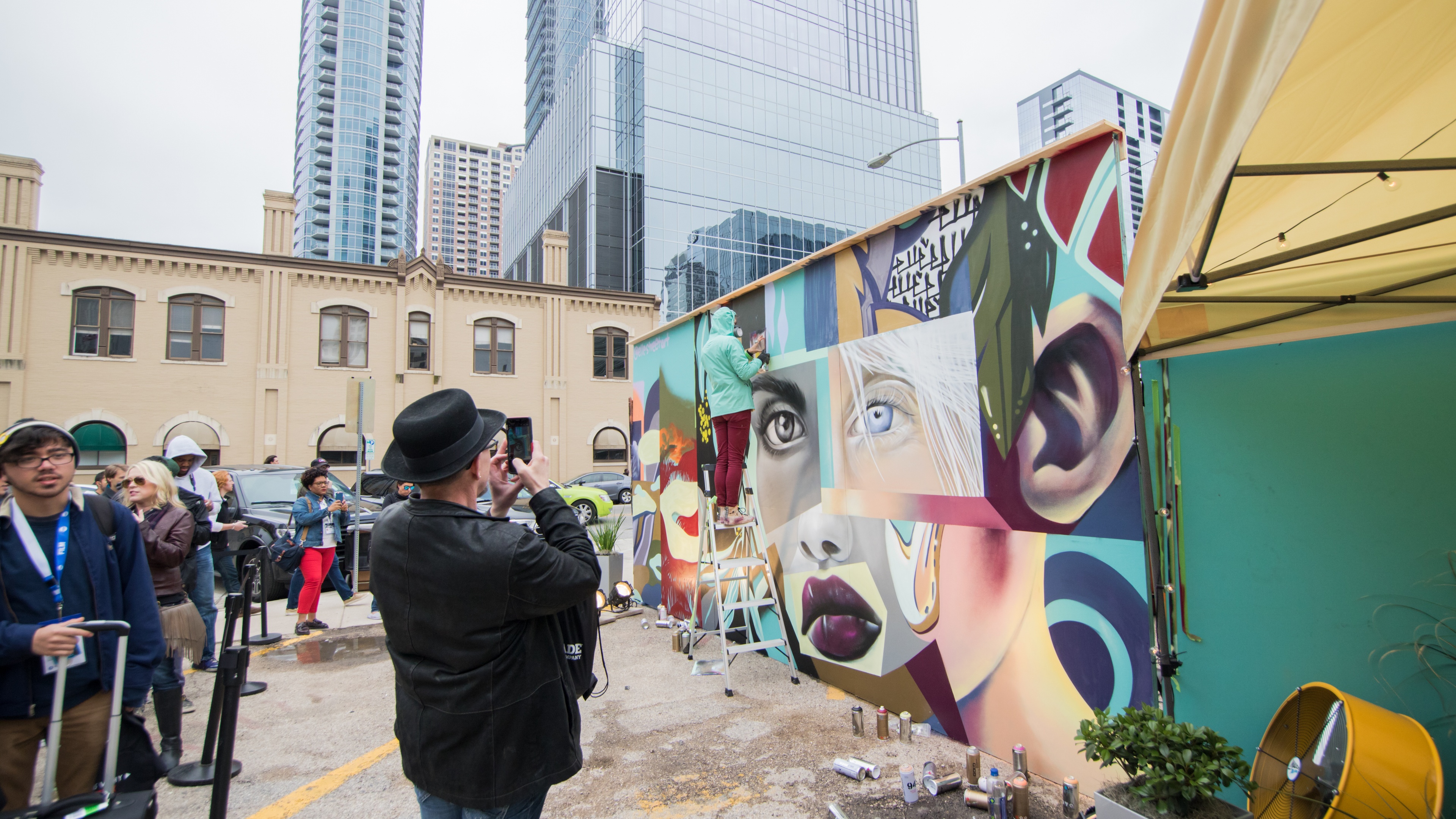 people taking photos of collage graffiti wall in city at brand activation