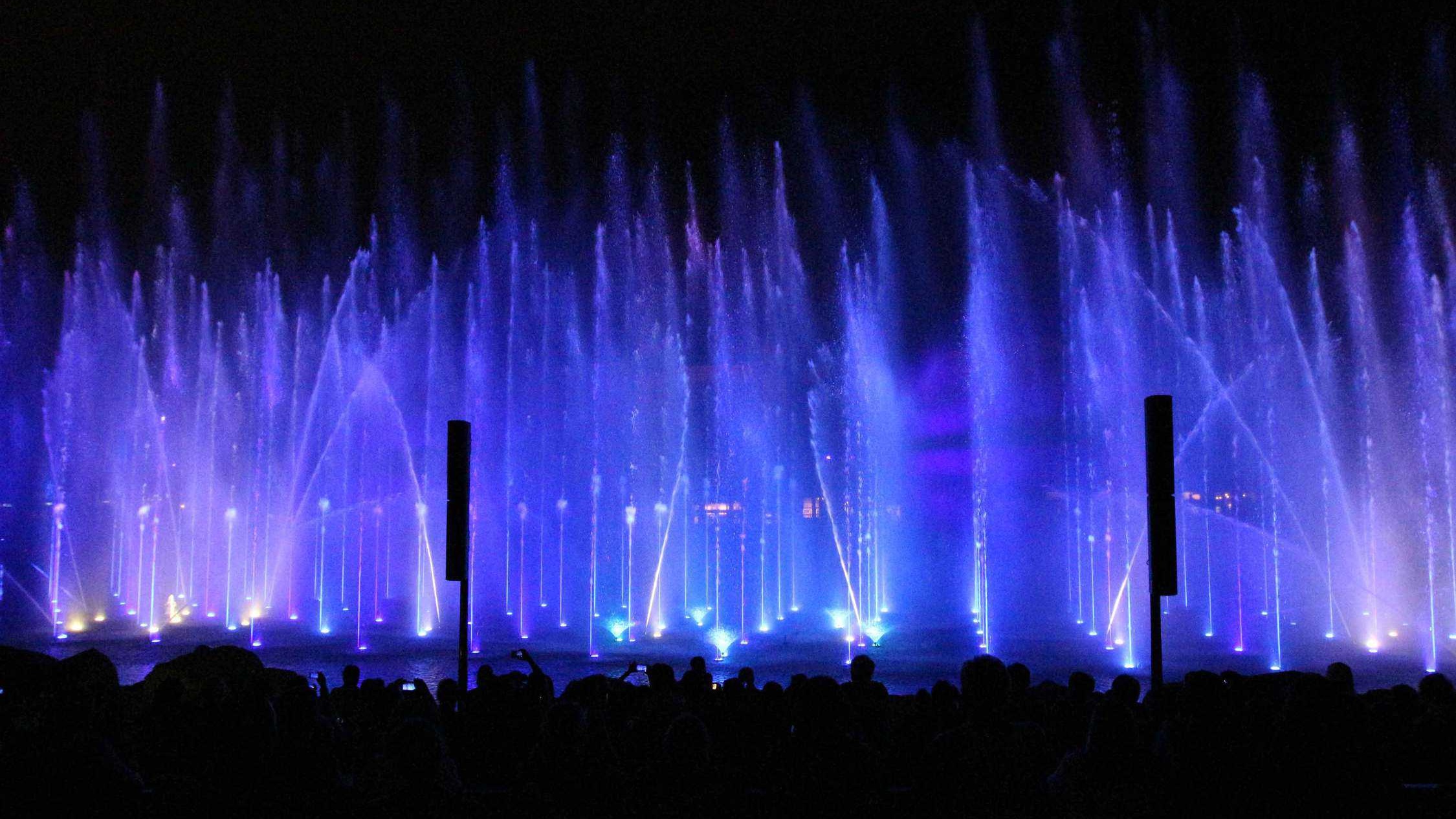 Blue light show at night with water