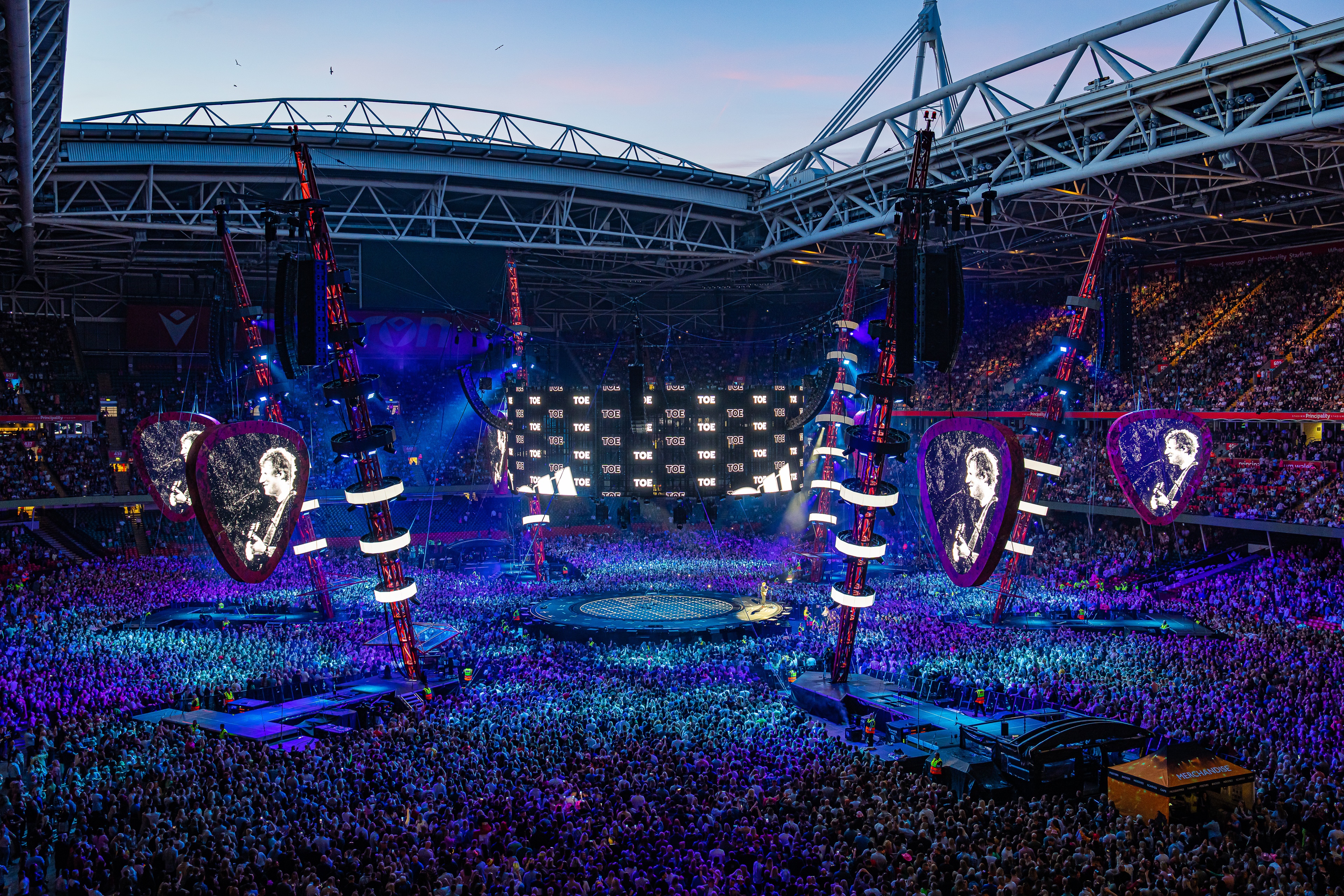 Ed Sheeran Mathematics stage lit up blue and purple surrounded by large stadium crowd