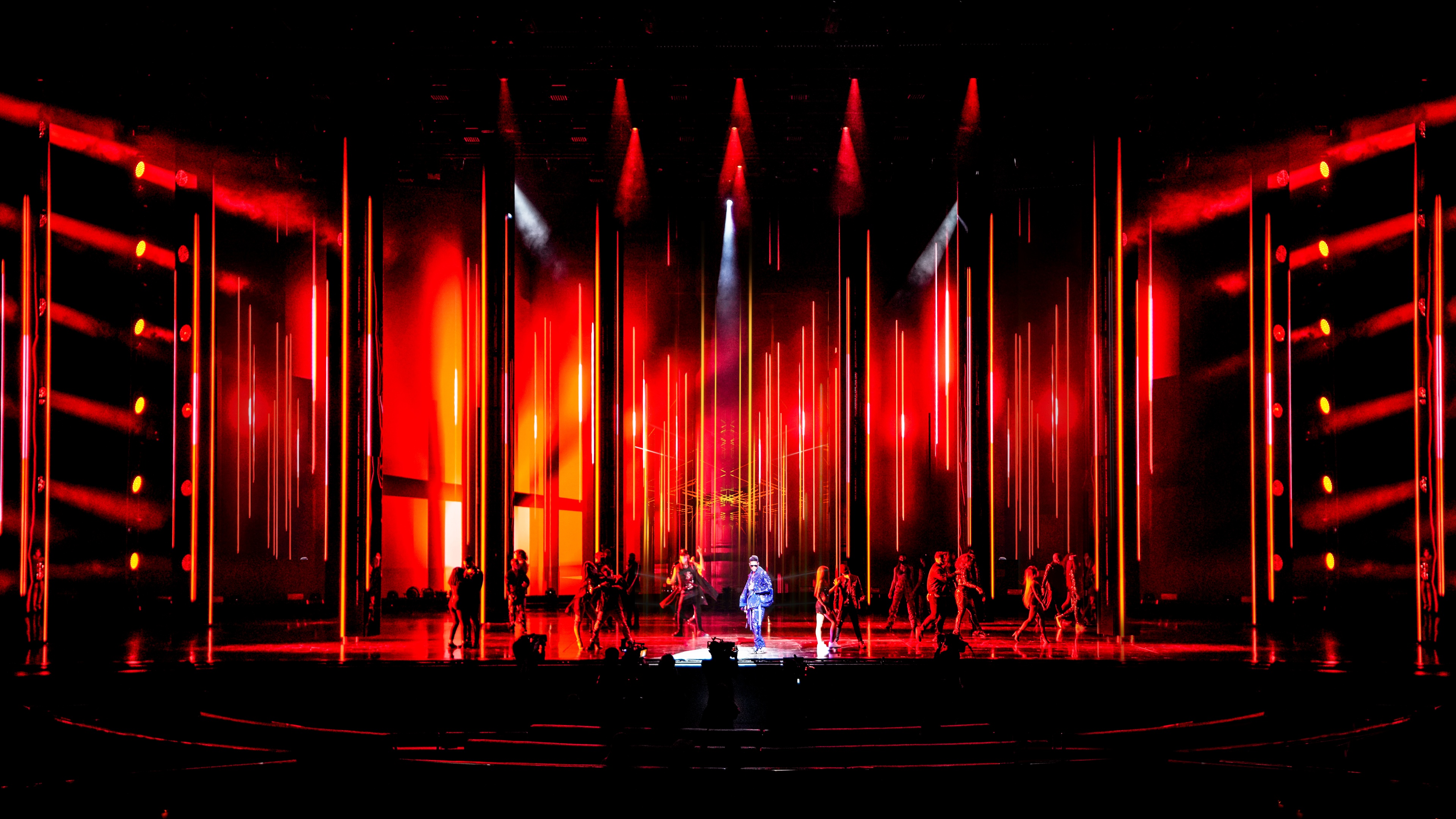 Usher performing with backup dancers at his Residency at The Colosseum at Caesars Palace, bright red stage with yellow tones