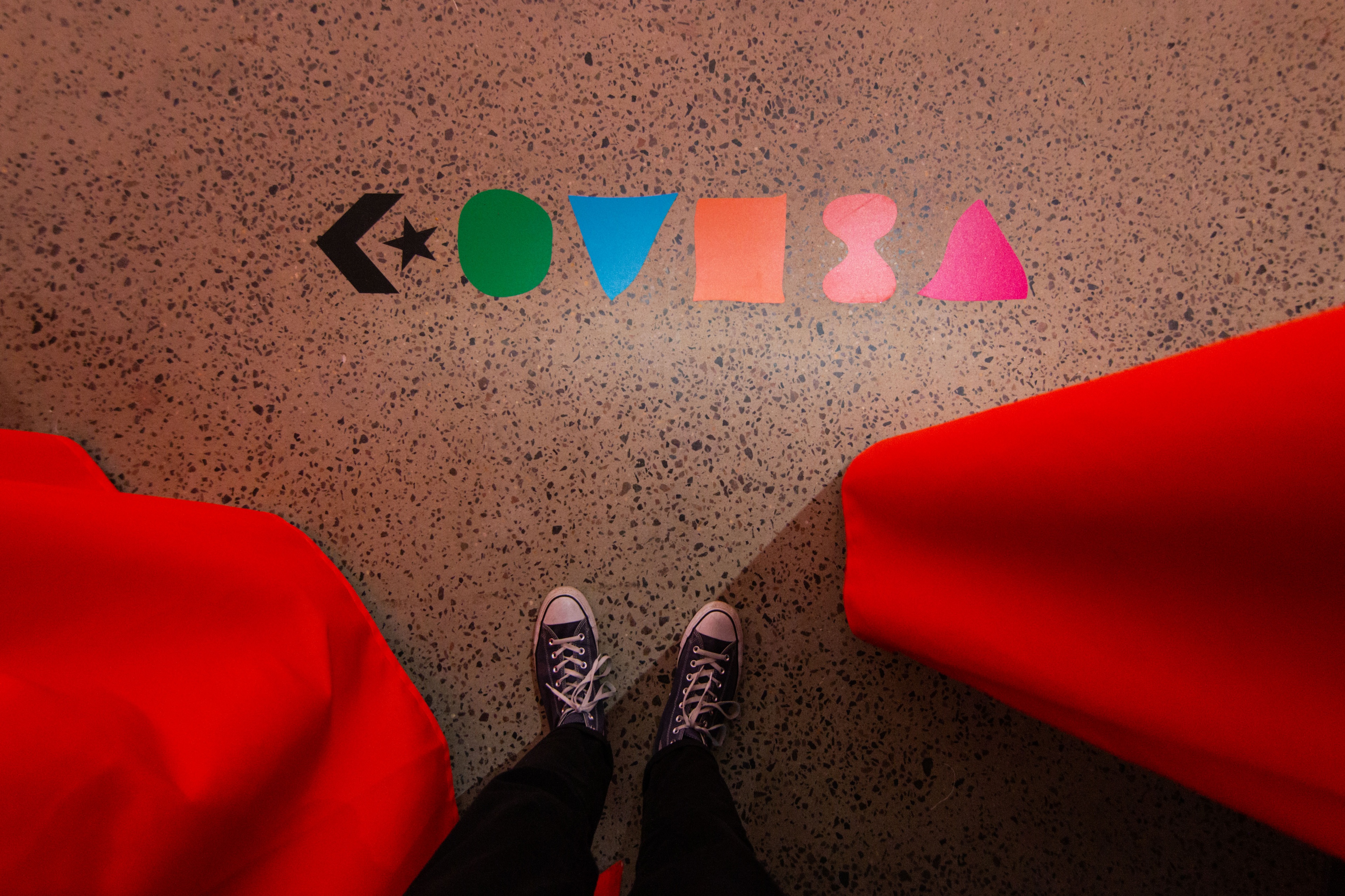 Converse logo in multiple colors on ground with shoes