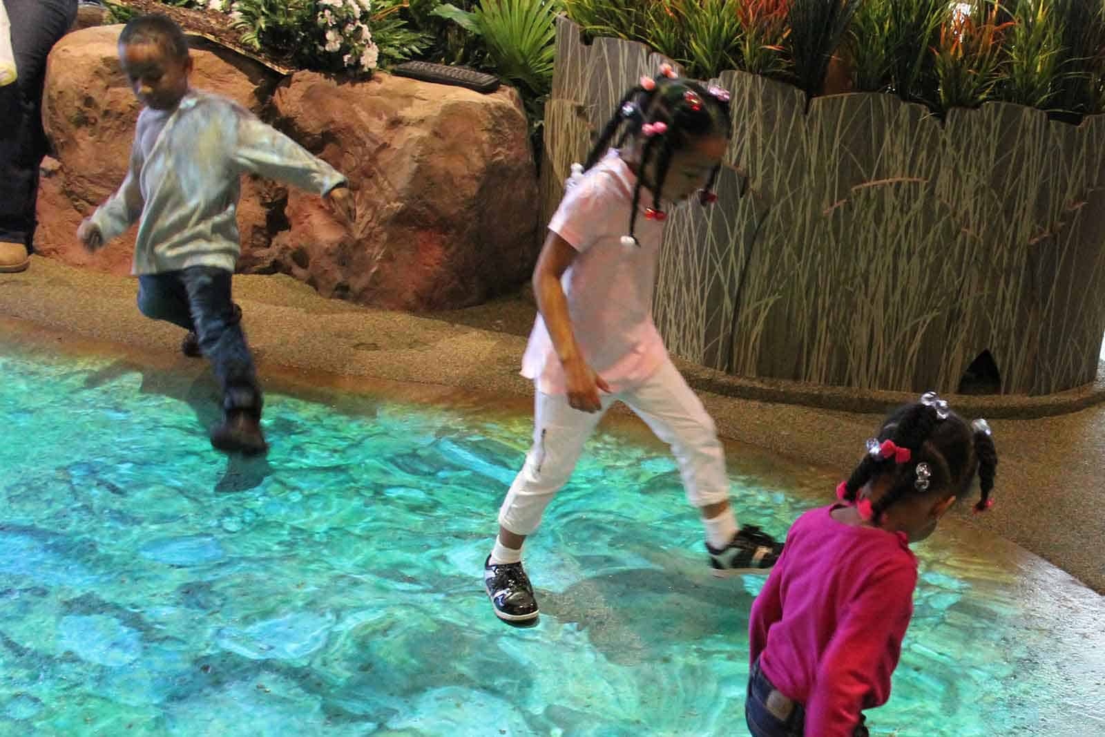 Kids playing on top of faux river