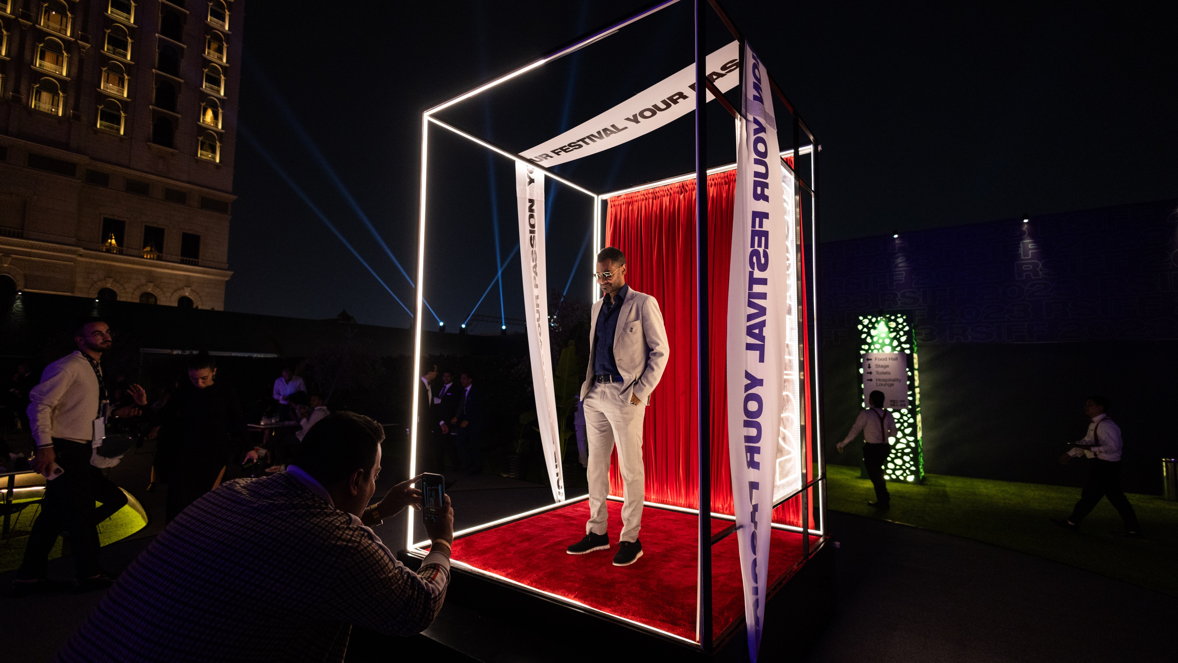 Man posing in photo box with red carpet