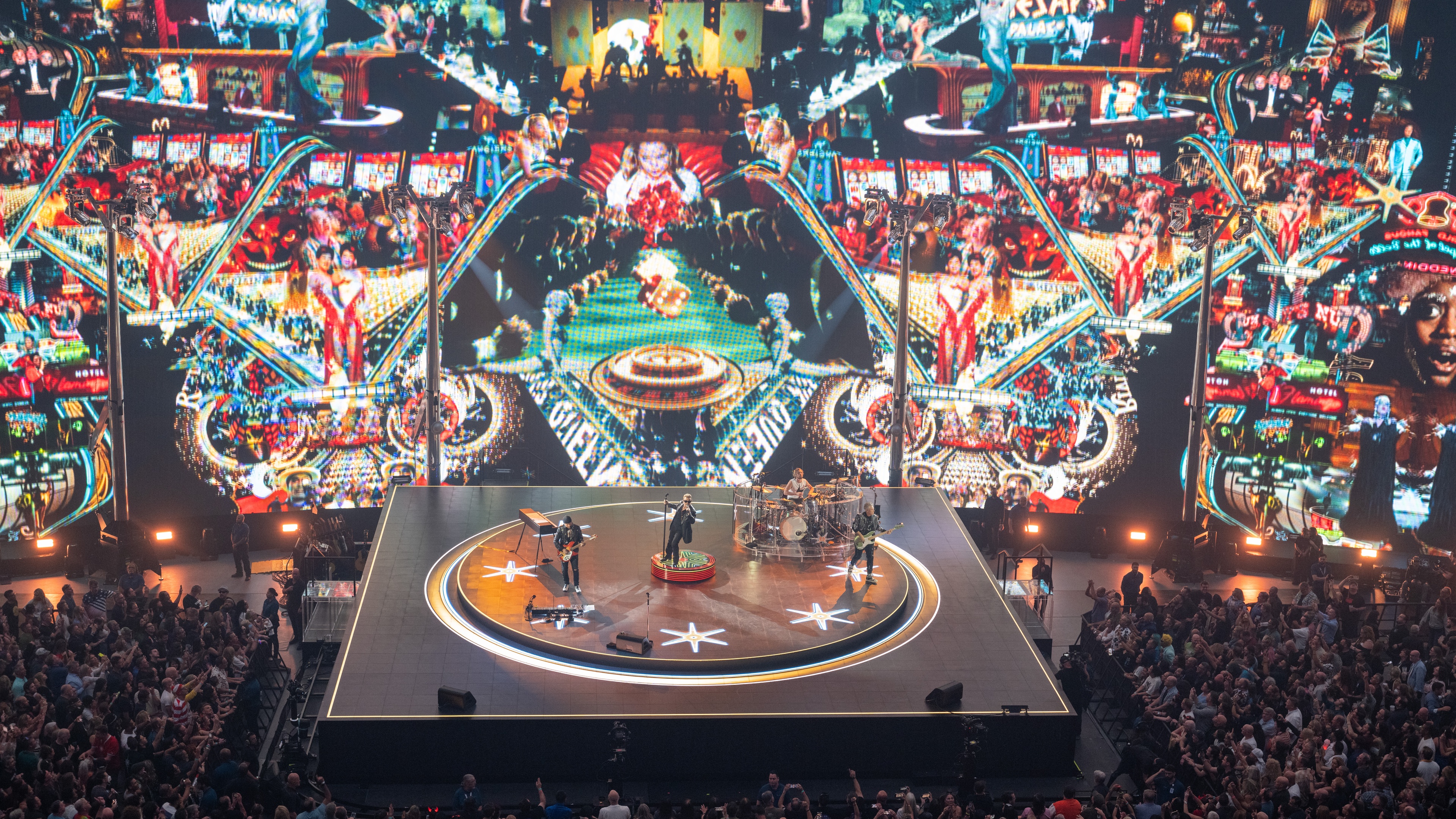 U2 playing on stage in front of photo collage huge LED screen backdrop at The Sphere Las Vegas