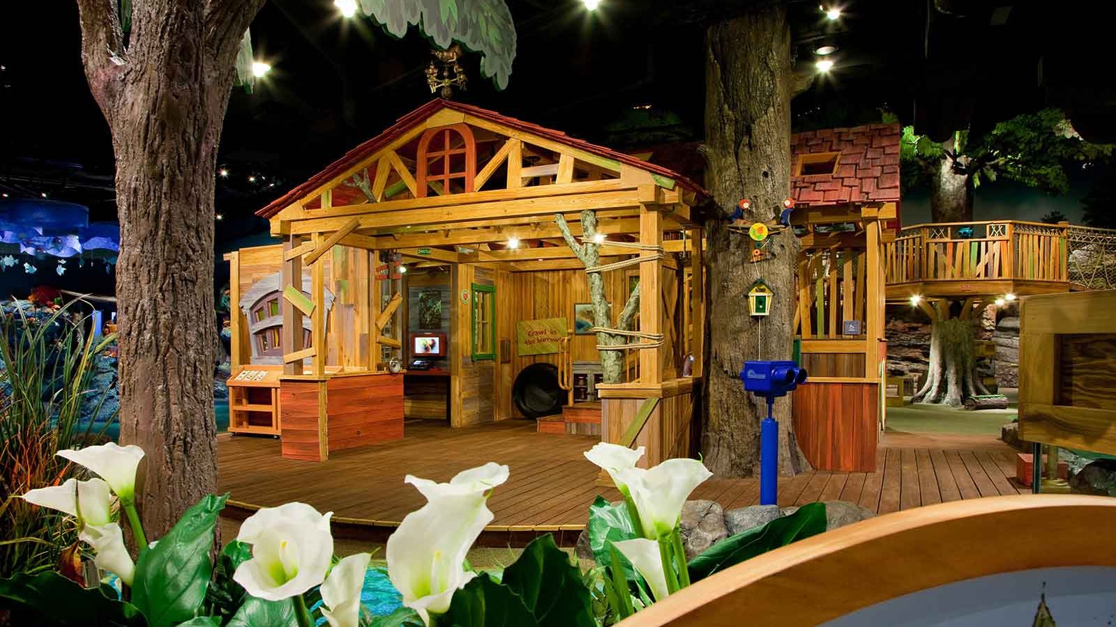 Wide shot of interactive exhibit with wooden cut out house and trees