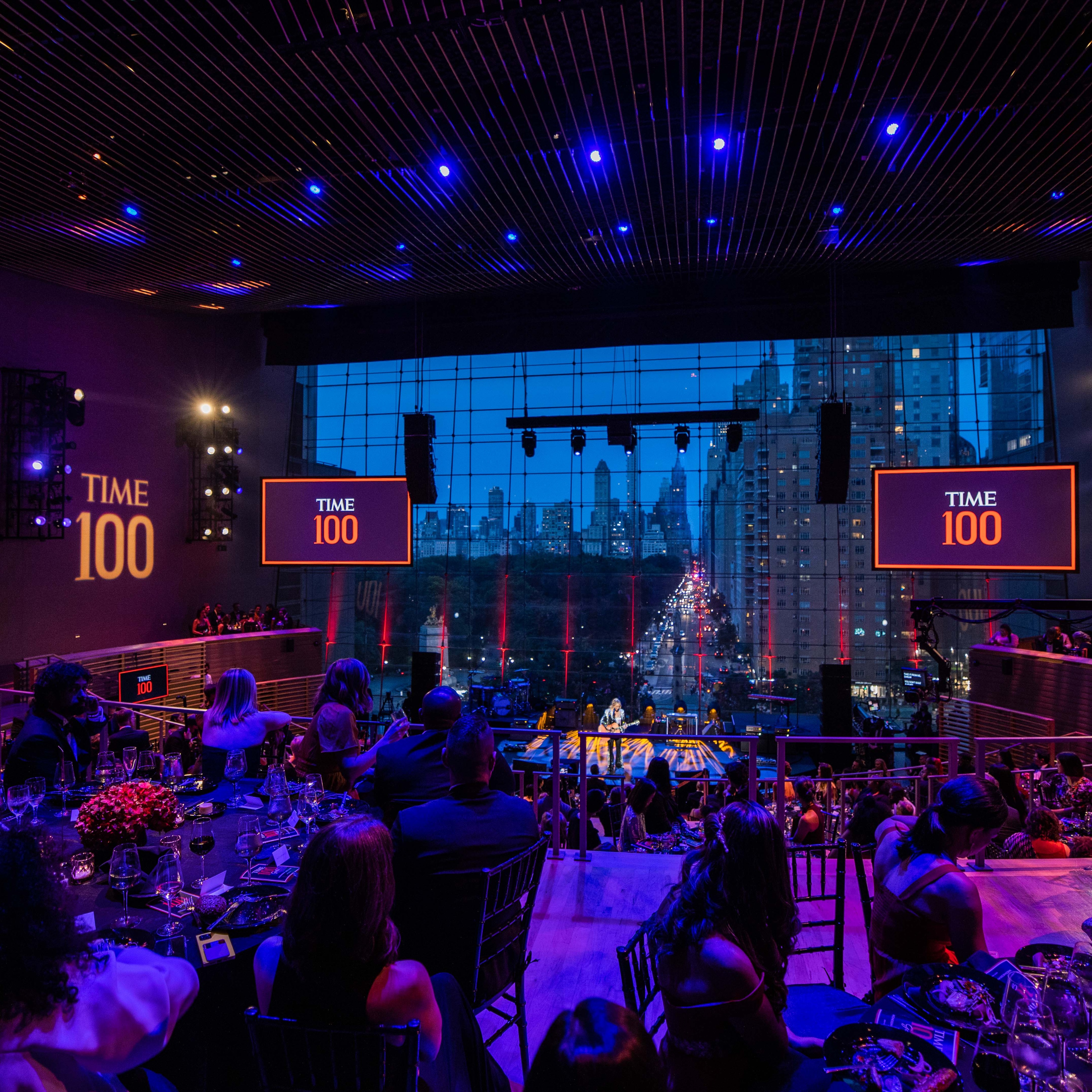 Wide view of TIME100 Gala stage in front of windows with New York skyline in the distance