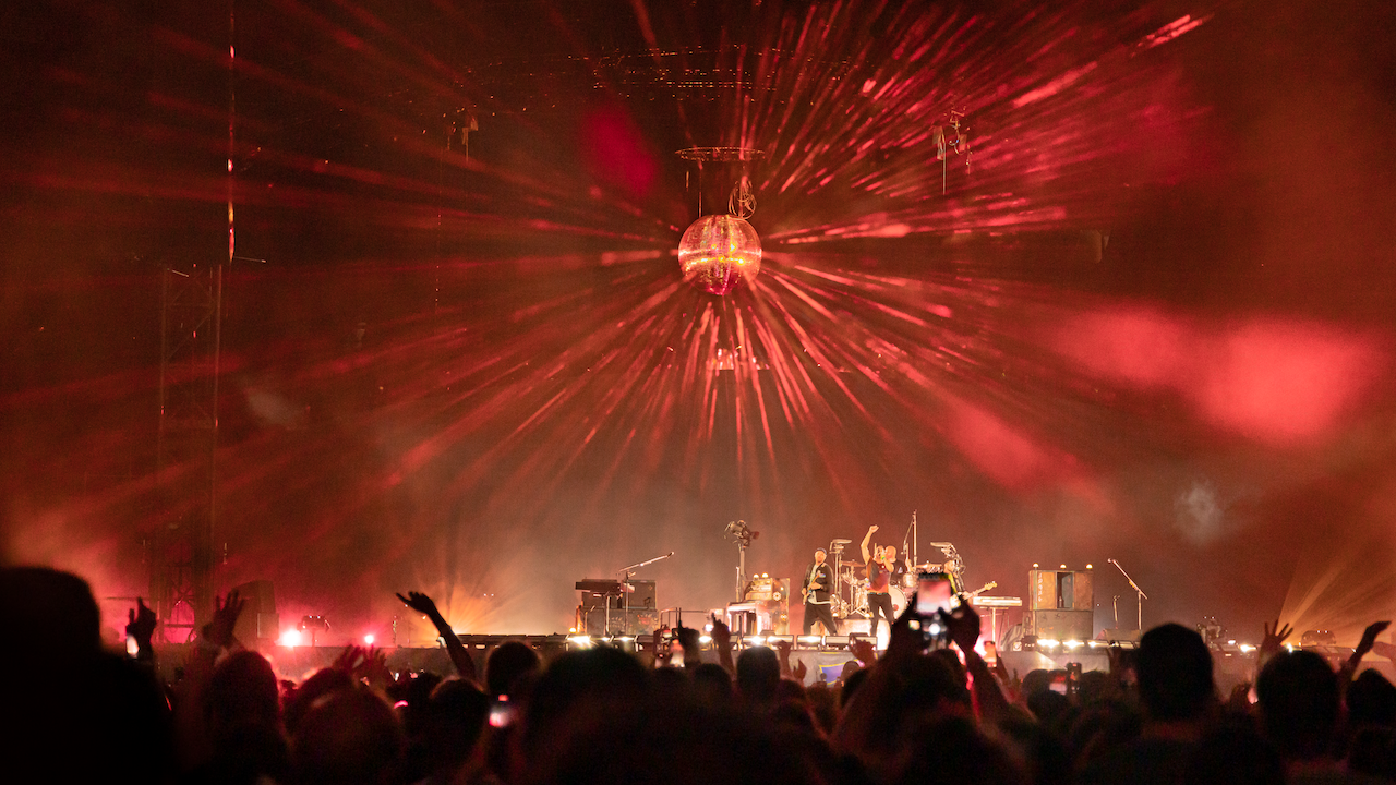 Disco ball shining with red lights above Coldplay Music of the Spheres stage