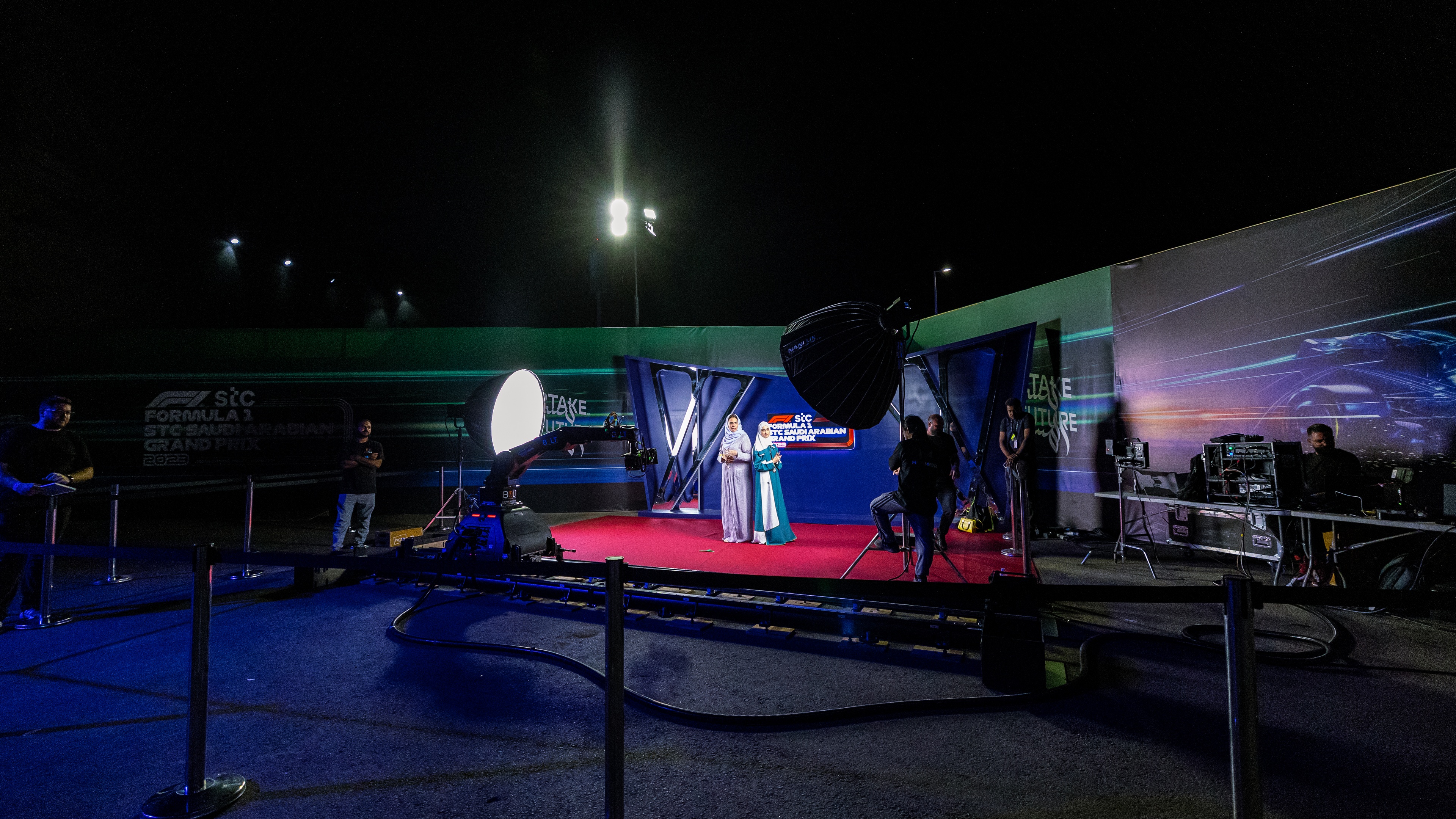 Formula 1 Saudi Arabian Grand Prix Concerts women posing for photo with F1 logo backdrop
