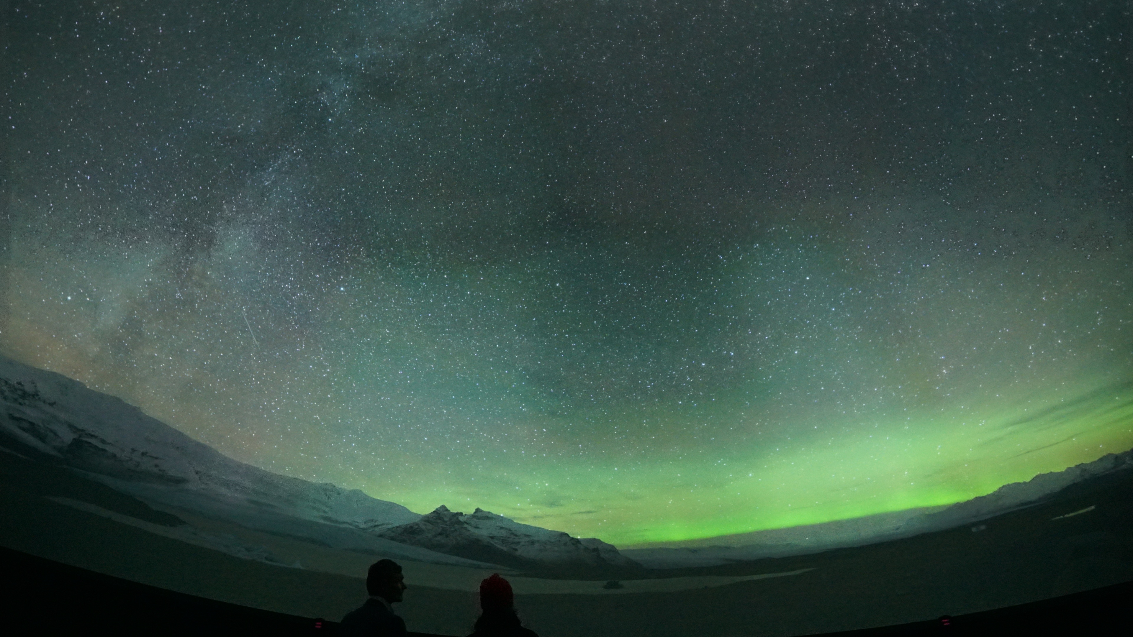 Planetarium with Northern Lights and two guests looking up