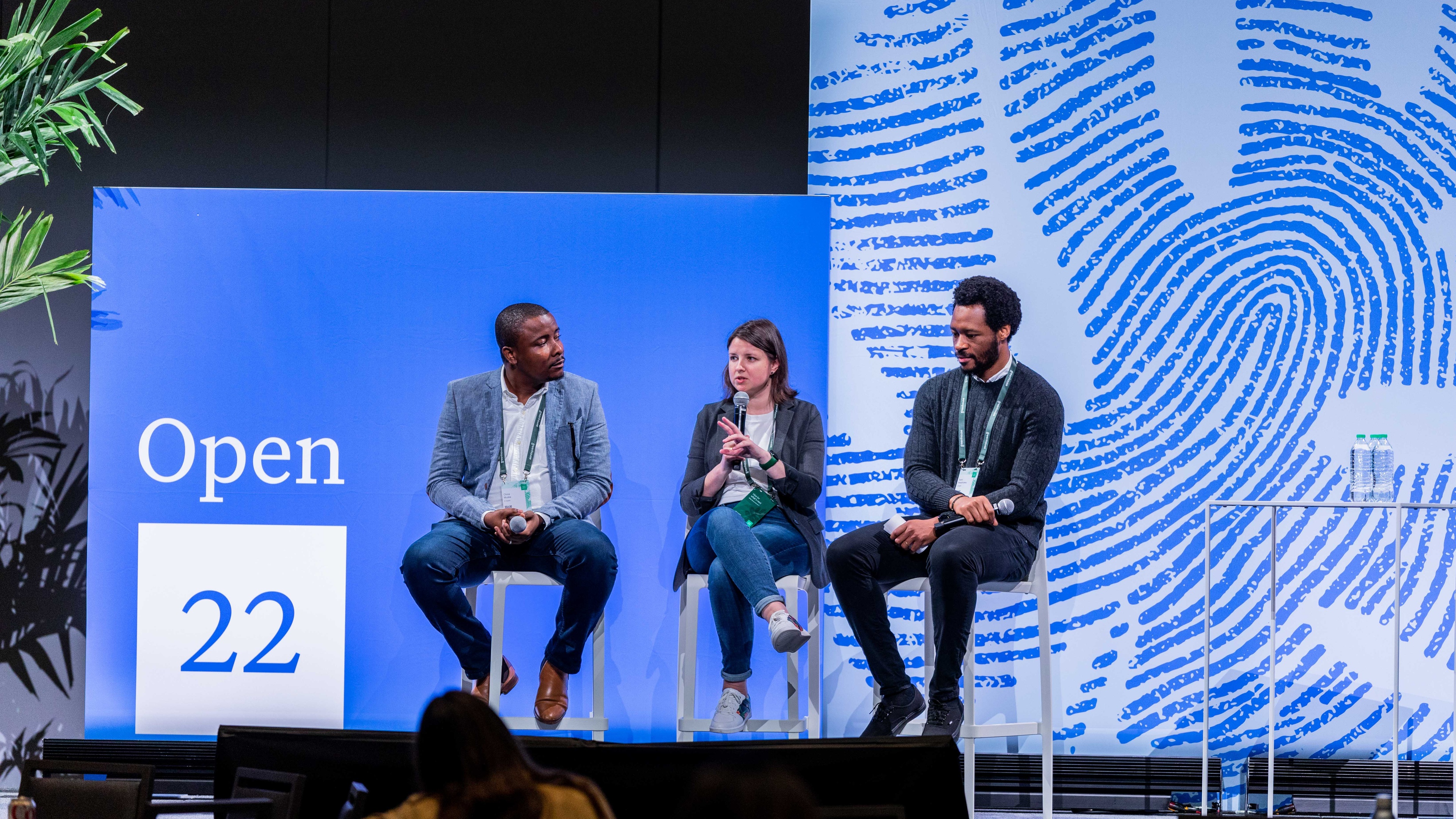 3 people sat on stools on stage at greenhouse conference 2022