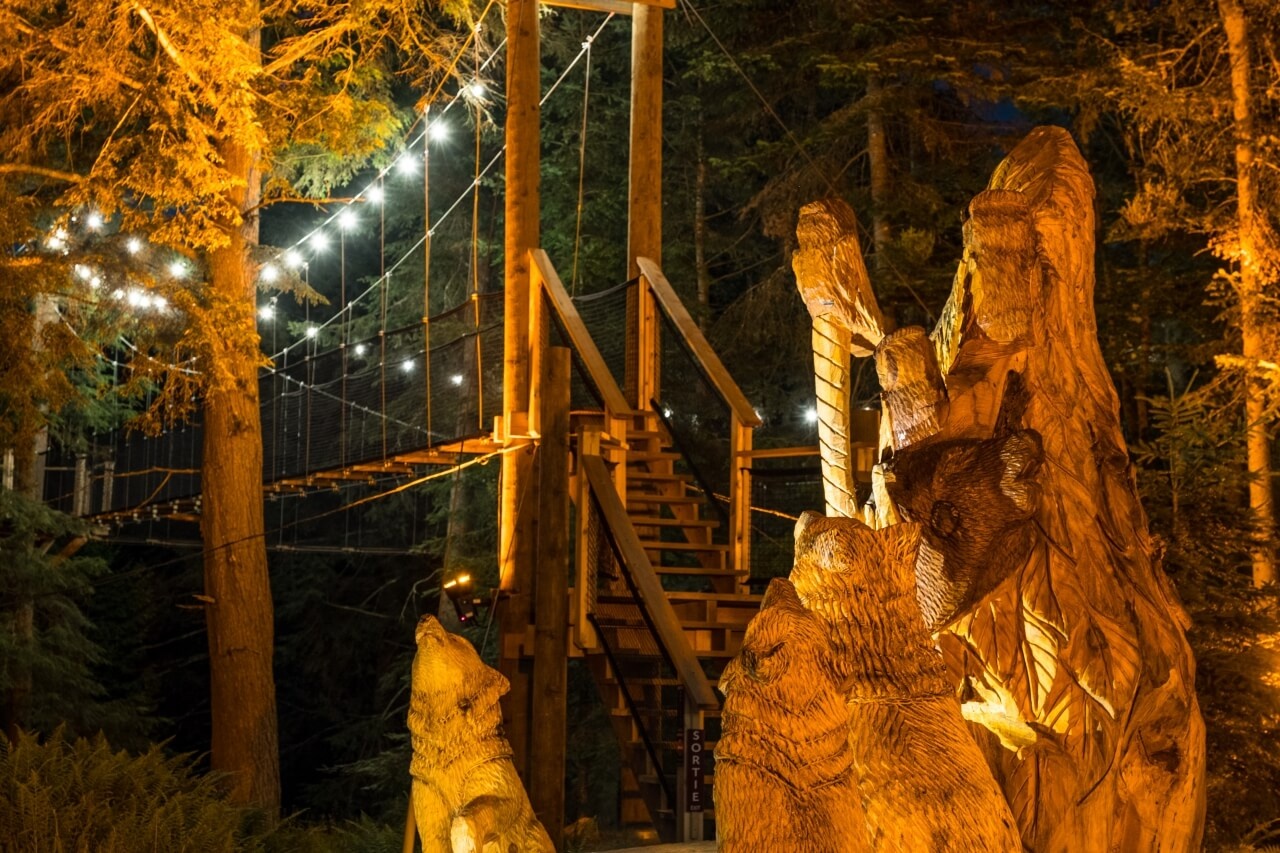 Forest with bridge, wood sculptors and warm yellow lighting