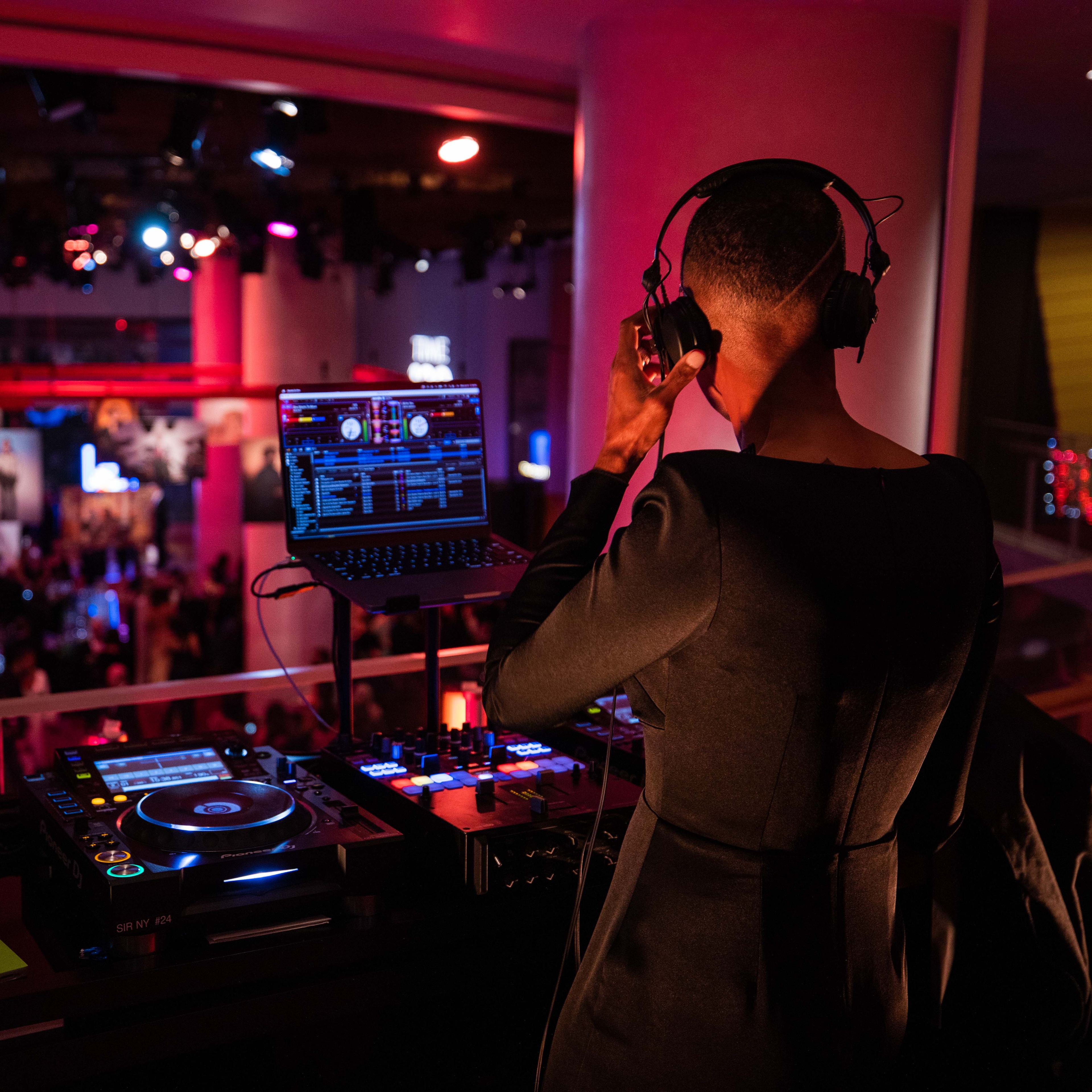 DJ in the foreground with TIME100 gala out of focus in the near distance