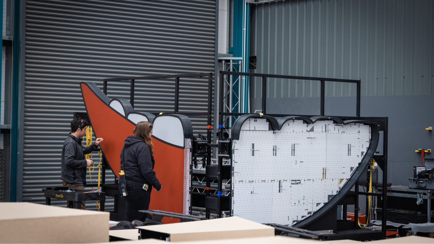 production workers piecing together a large mouth element from the stage design