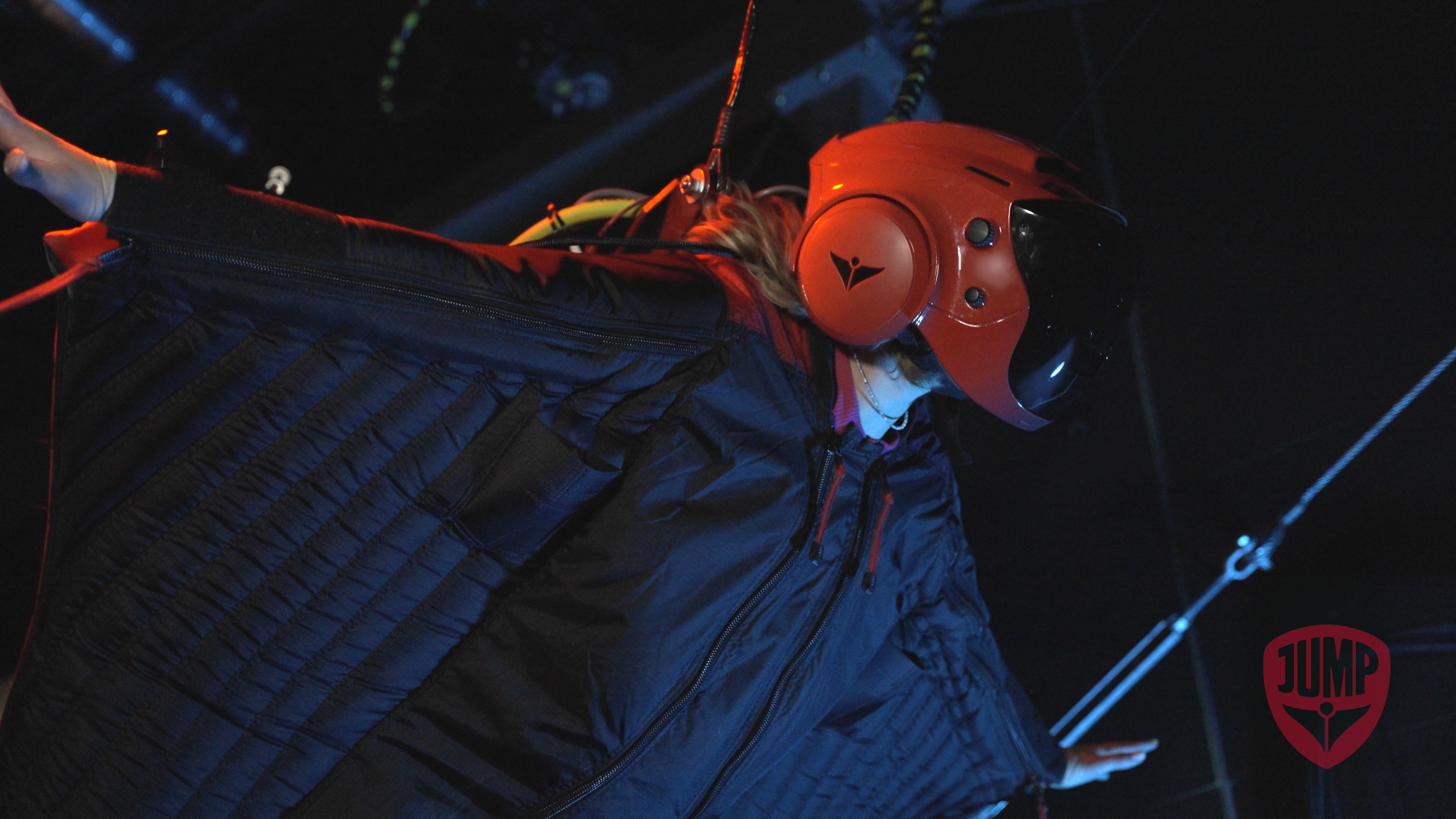 Woman wearing wing suit in virtual simulator