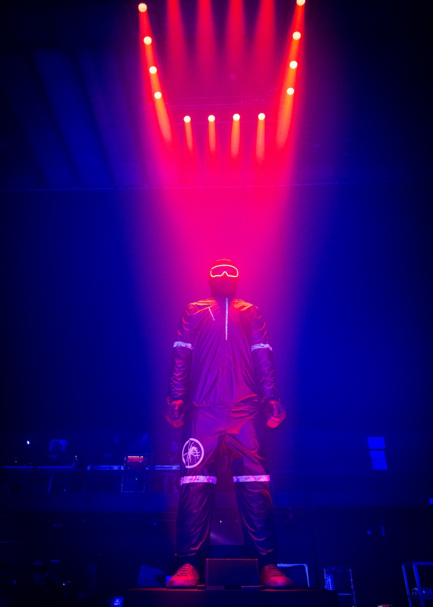 Huge sculpture of man in black overalls with red spotlights