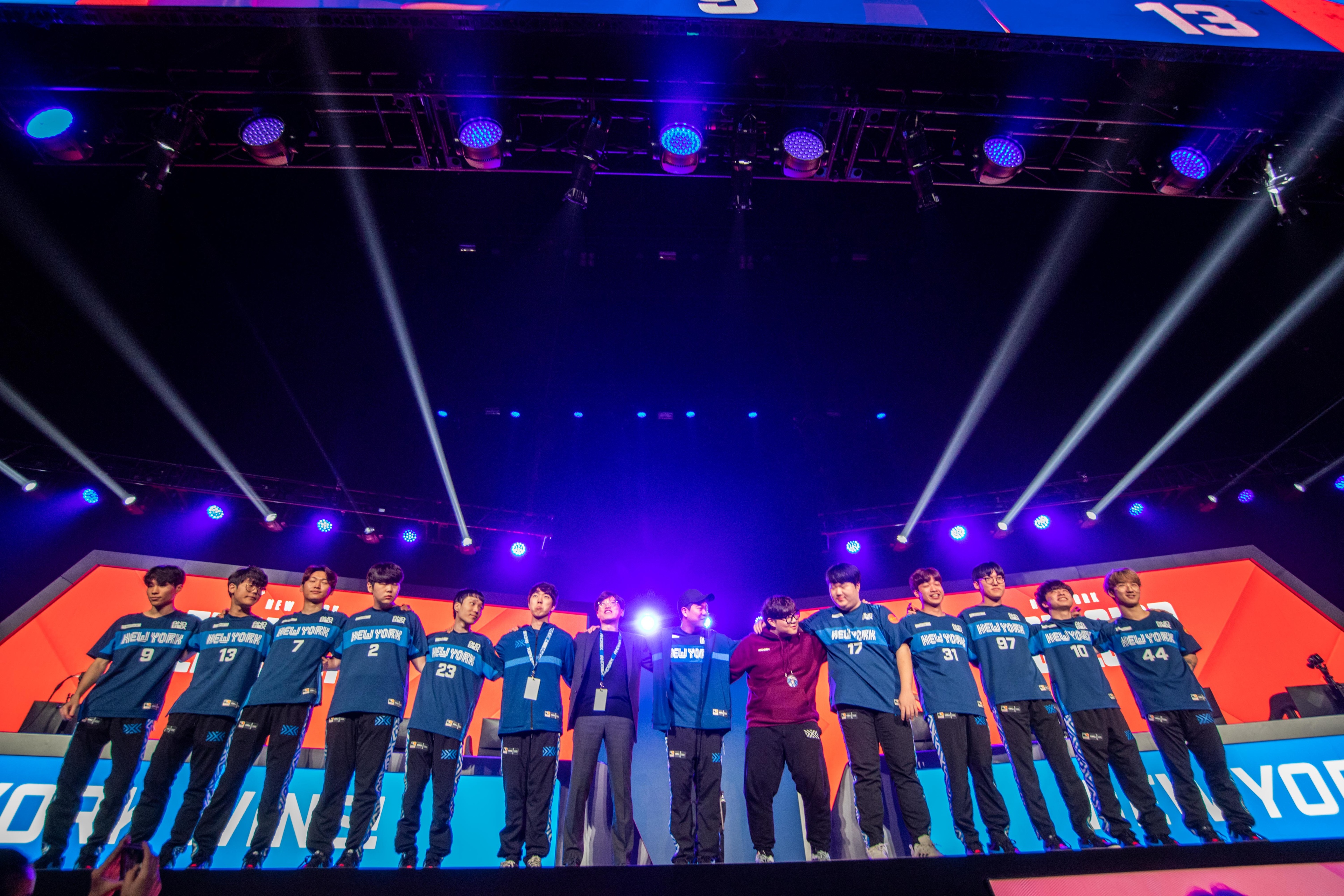 Wide shot of New York team standing on stage posing for photo