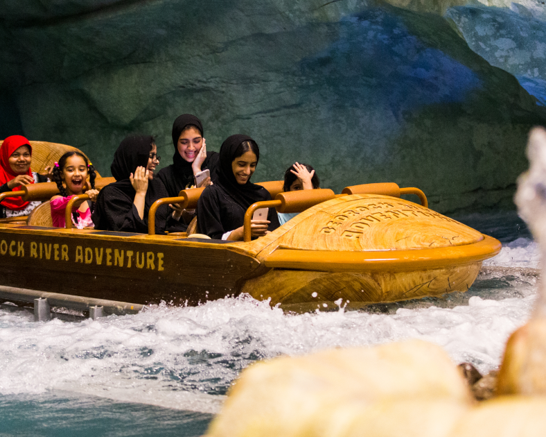 people riding amusement ride through water