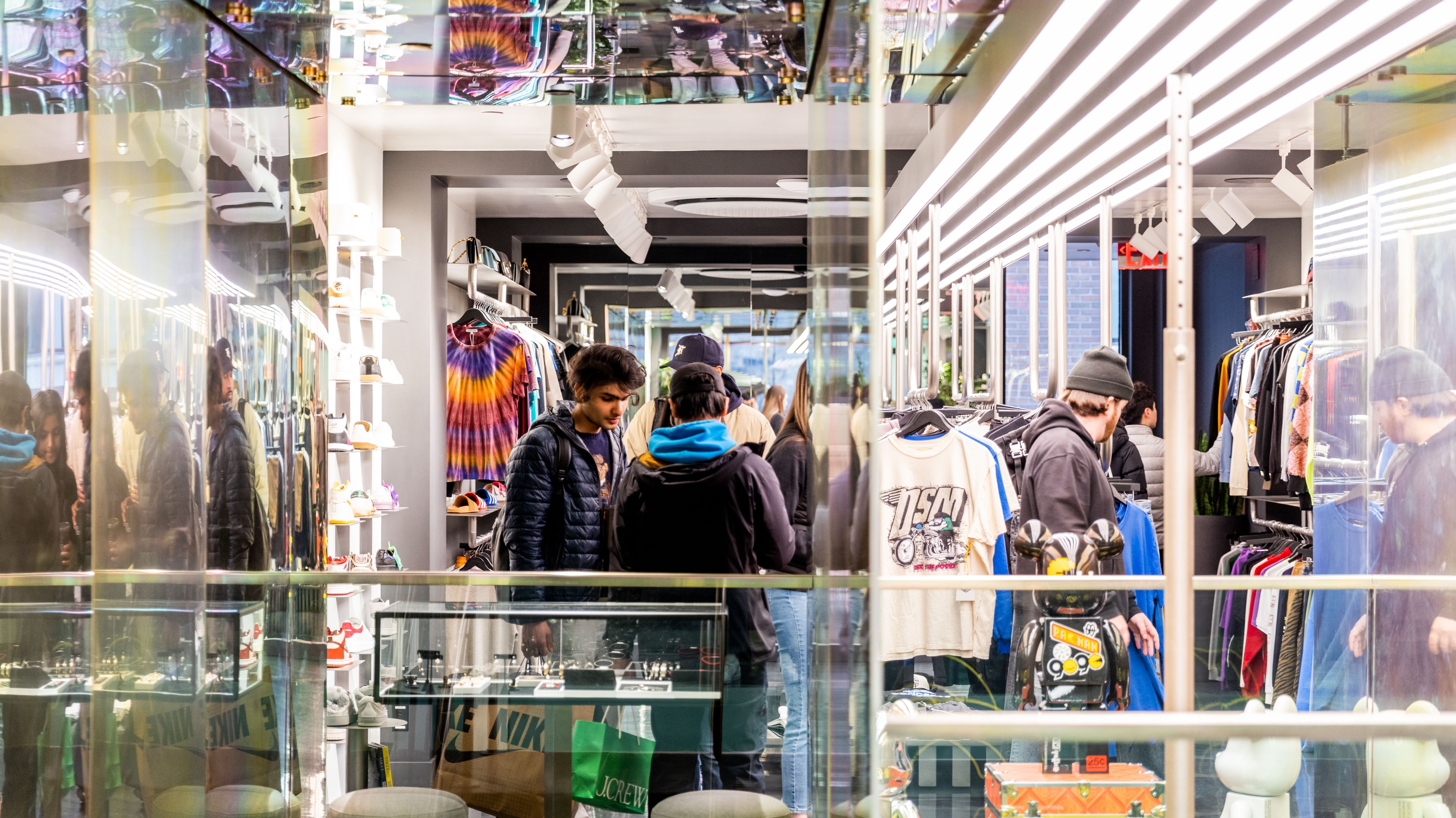 People interacting with Nike brand experience with mirror walls merchandise and soft lighting