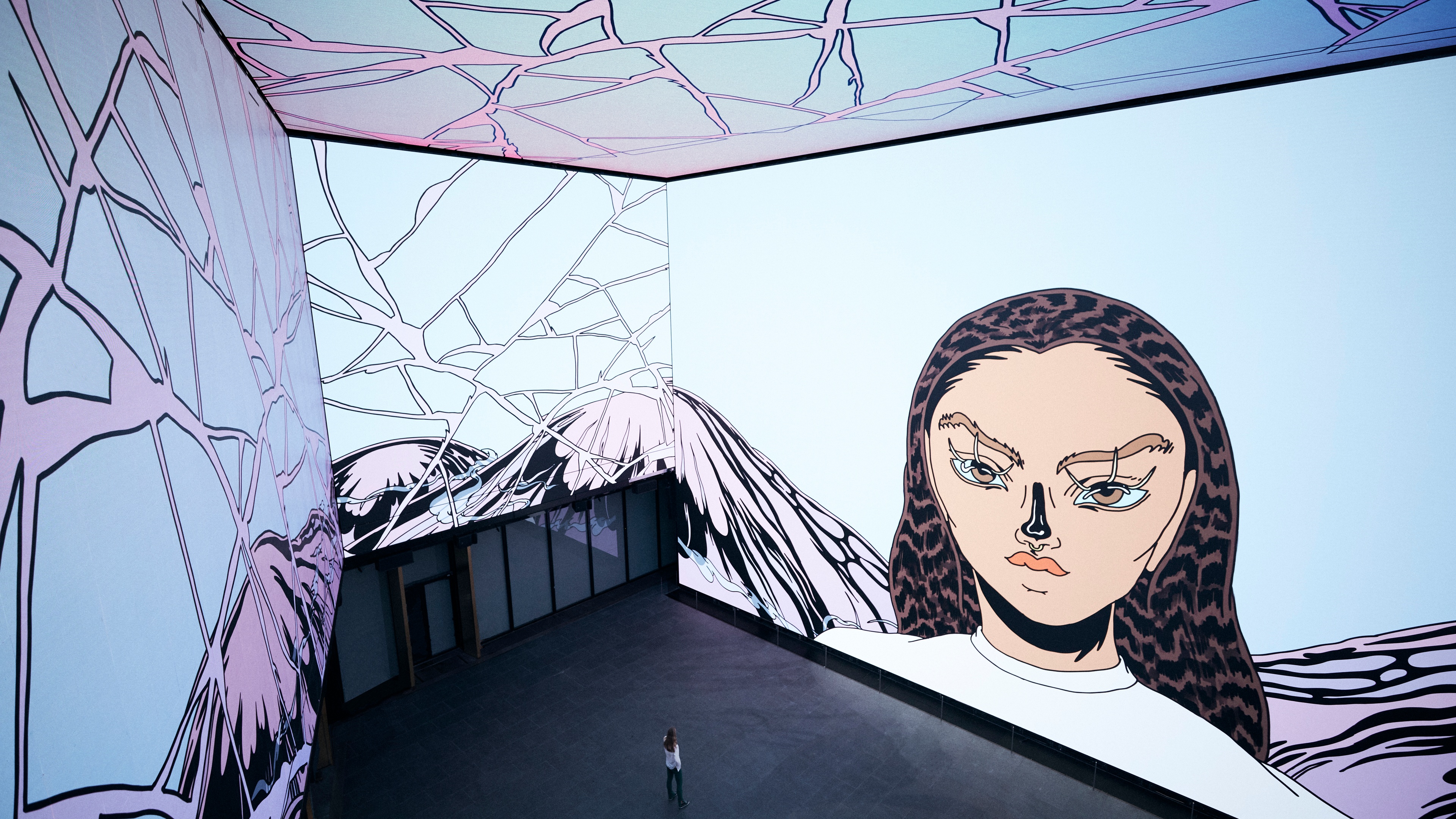 Huge LED screen room with graphic artwork surrounding person stood in the middle
