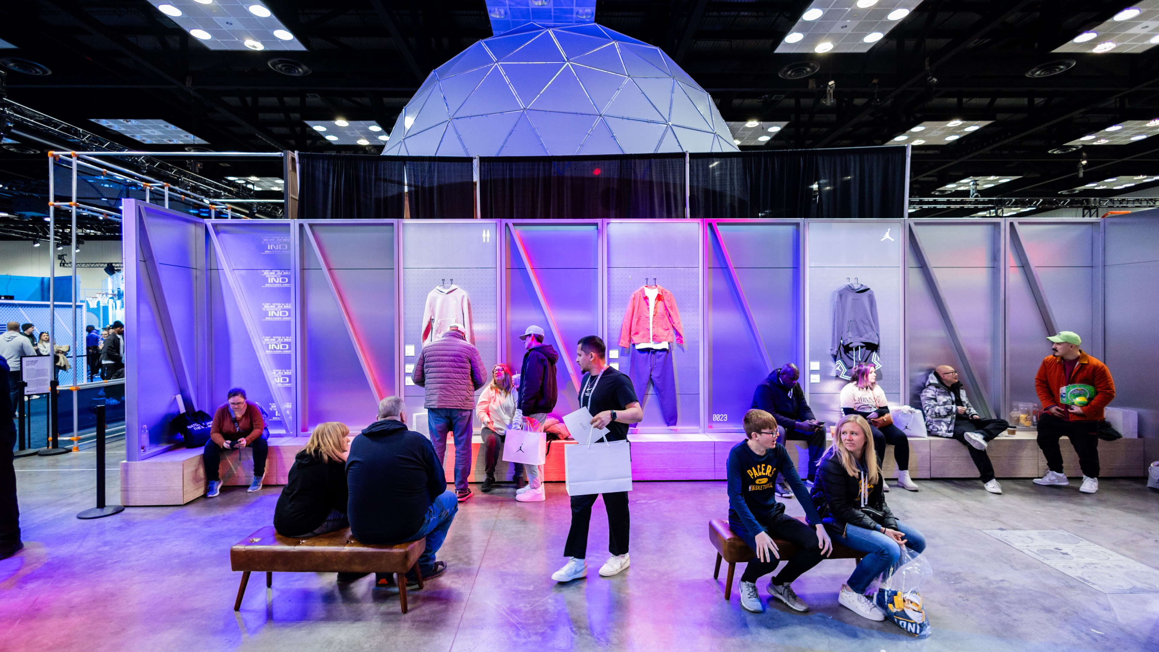 People gathered at a brand activation sitting down with sports wear modelled on mannequins 