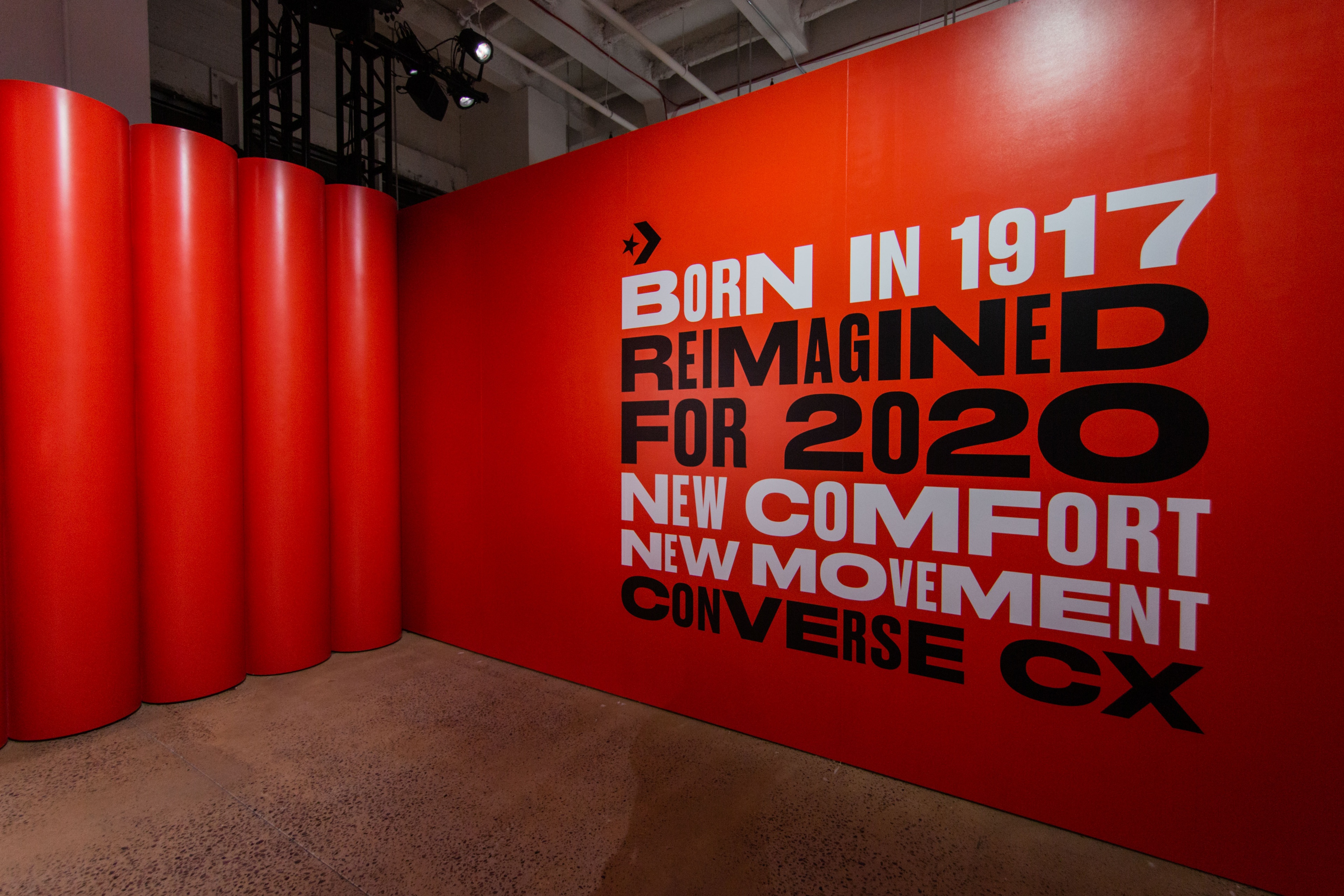 Red wall with "Born in 1917 reimagined for 2020 new comfort new movement Converse CX" on it