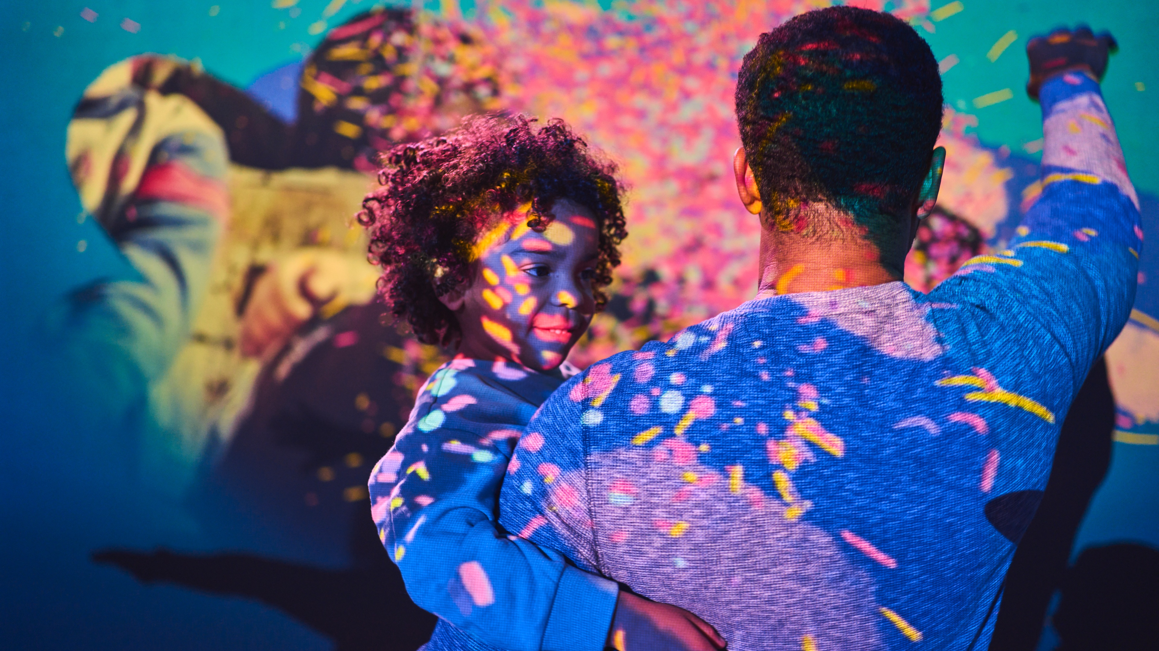 Father holding son and pointing at display