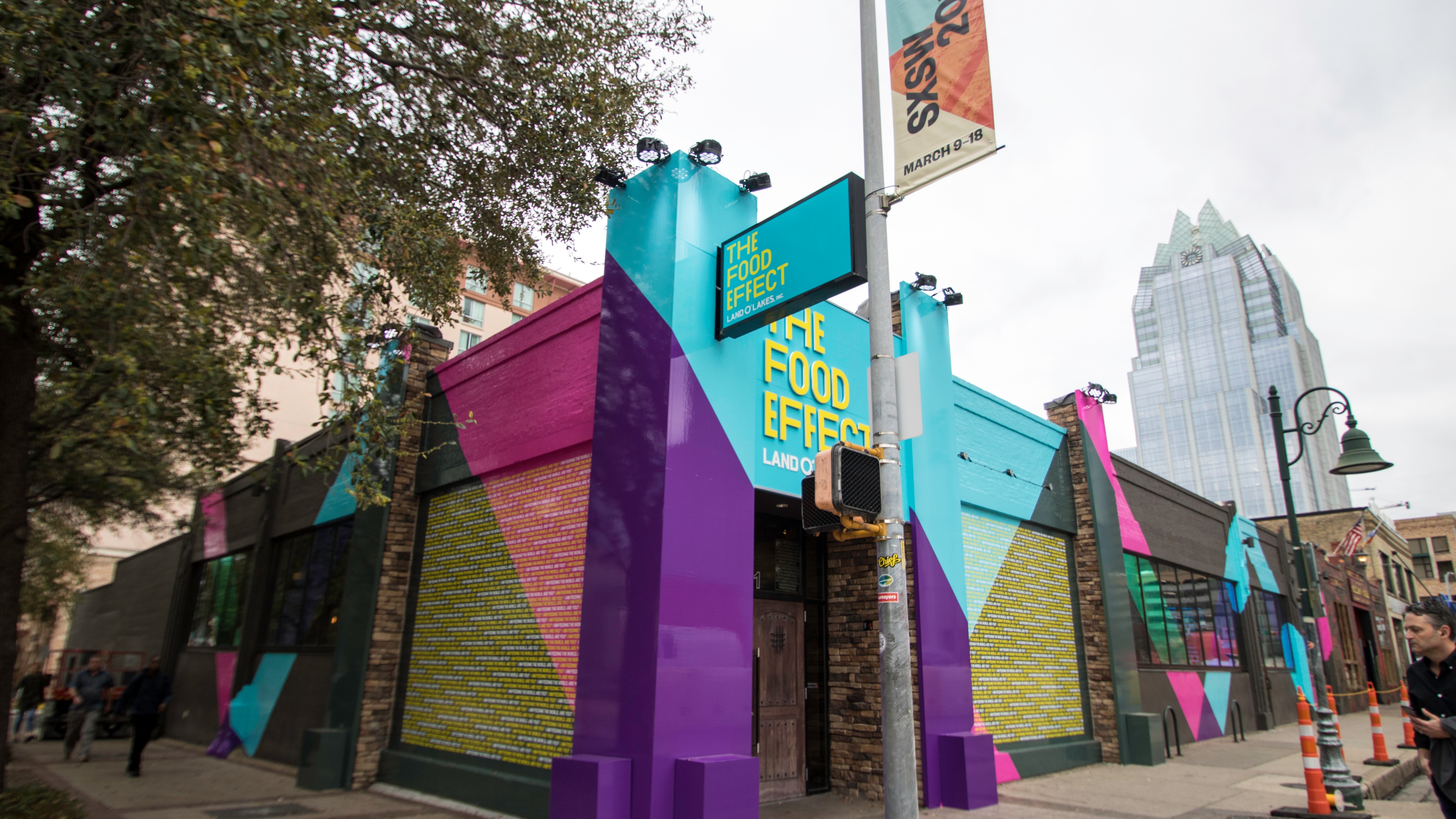 view of the Land O’Lakes The Food Effect SXSW building painted in geometrical shapes clored purple, pink, cyan, and greem
