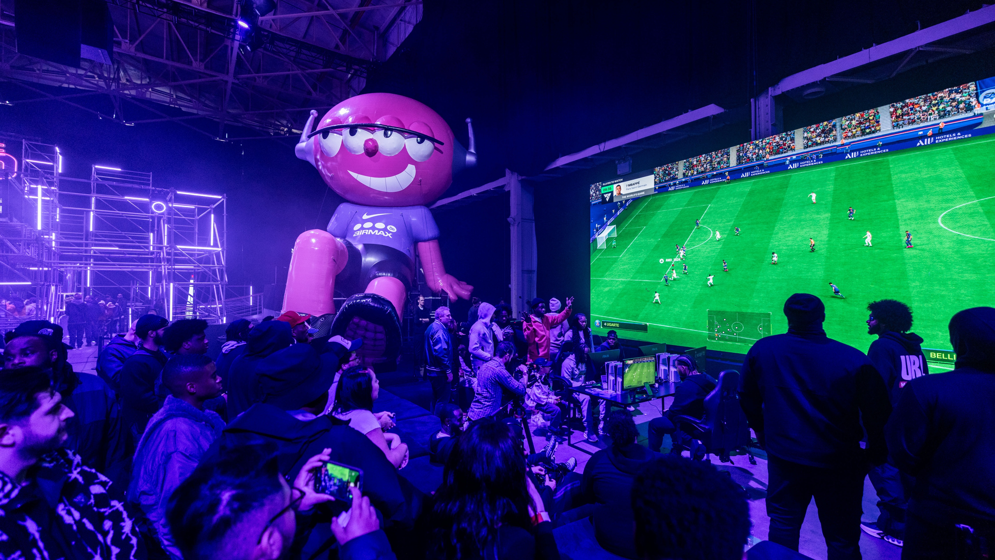 Crowd gathered in front of screen showing soccer