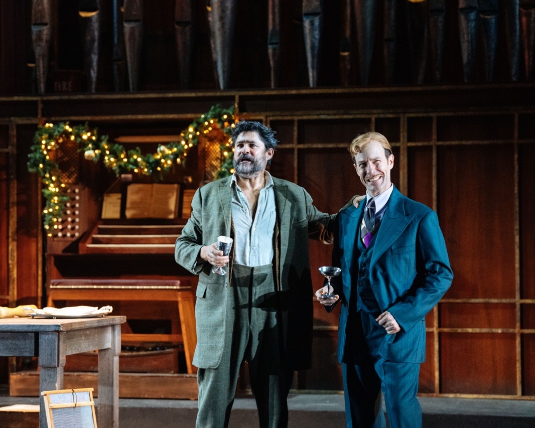 2 male performers singing in front of christmas theme piano