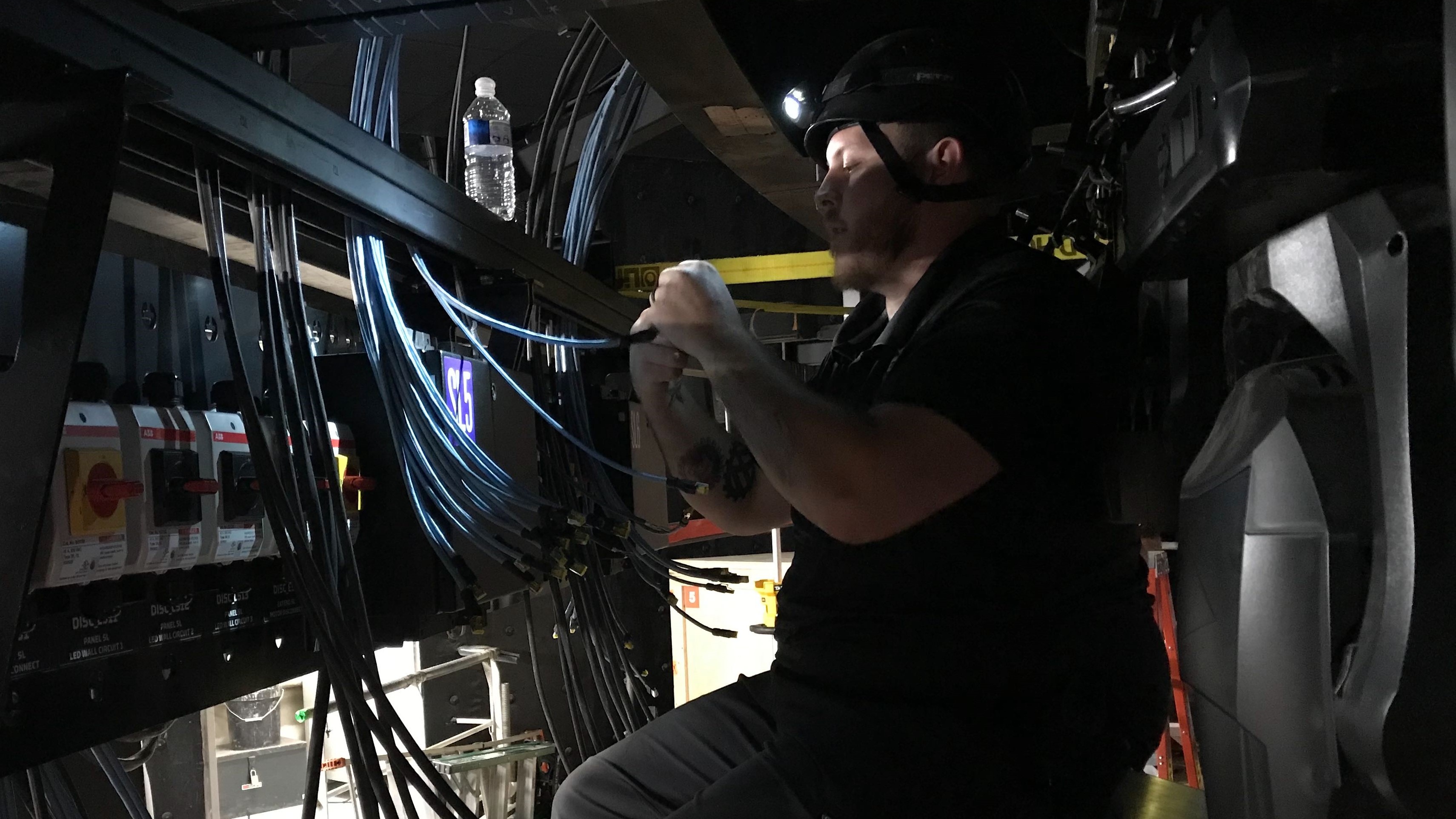 Person working with wiring below stage