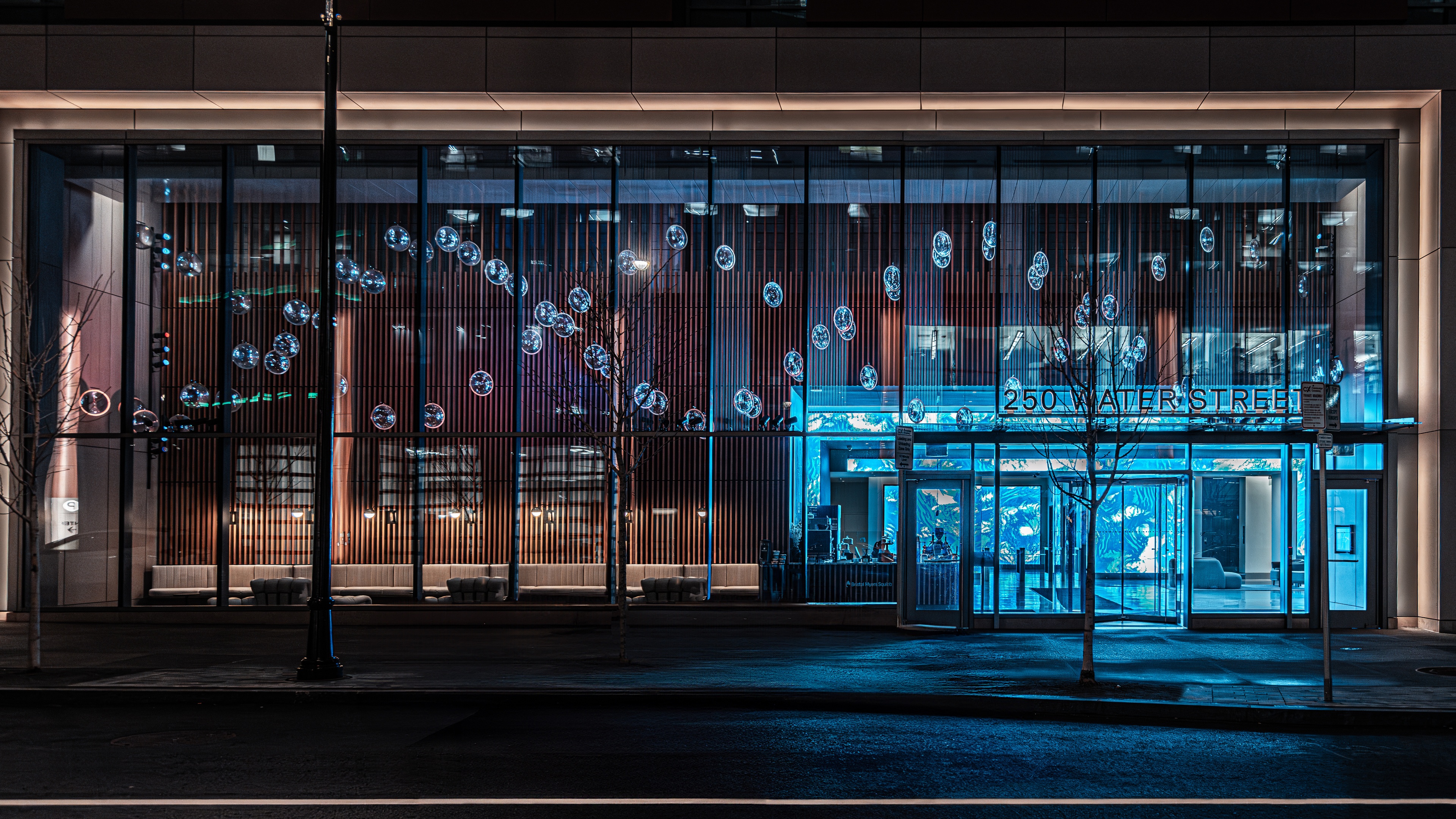 Exterior shot of Bristol Myers Squibb lobby with chandelier and blue accent lighting