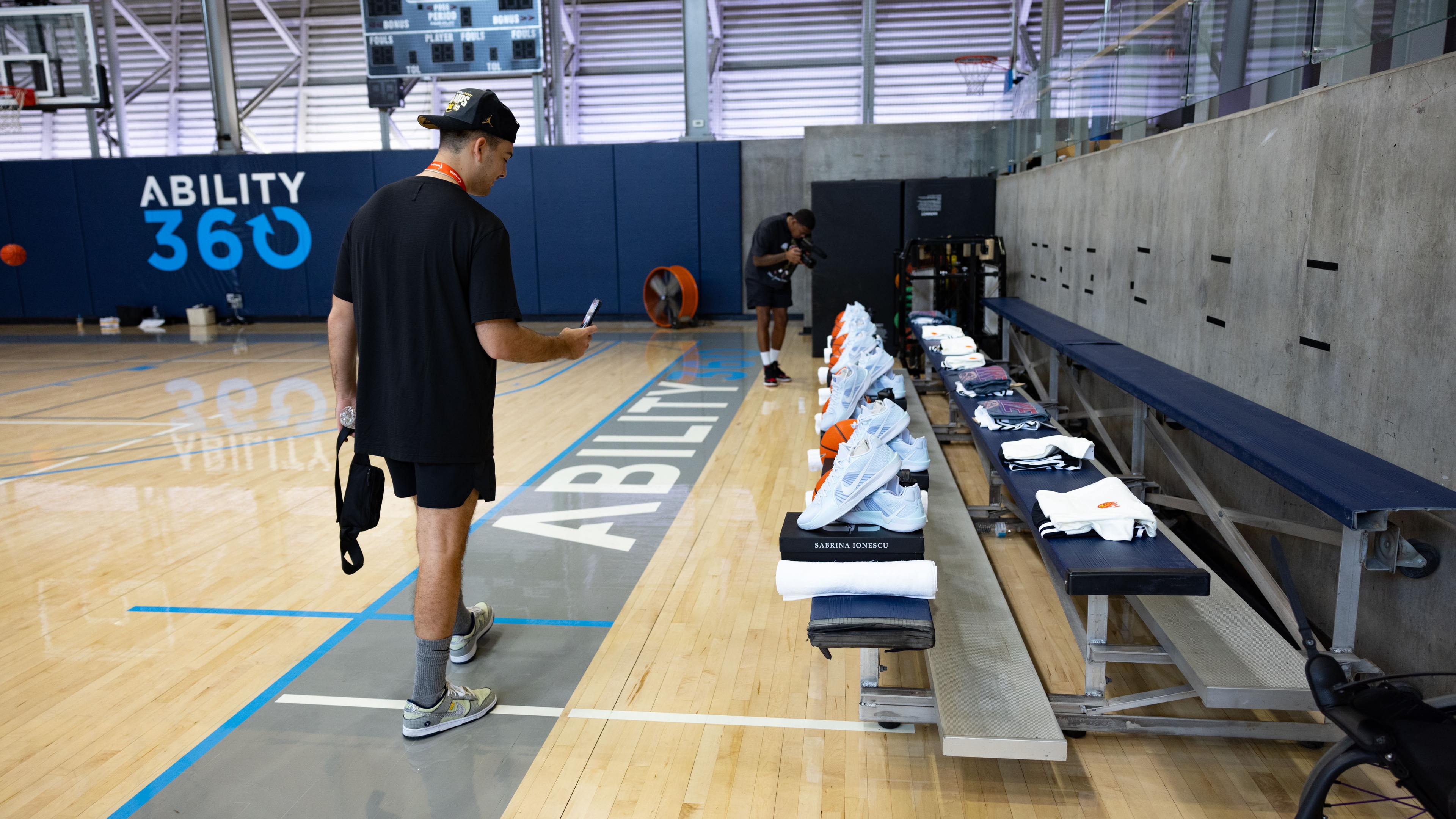 Man taking photo of Nike shoes displayed on court