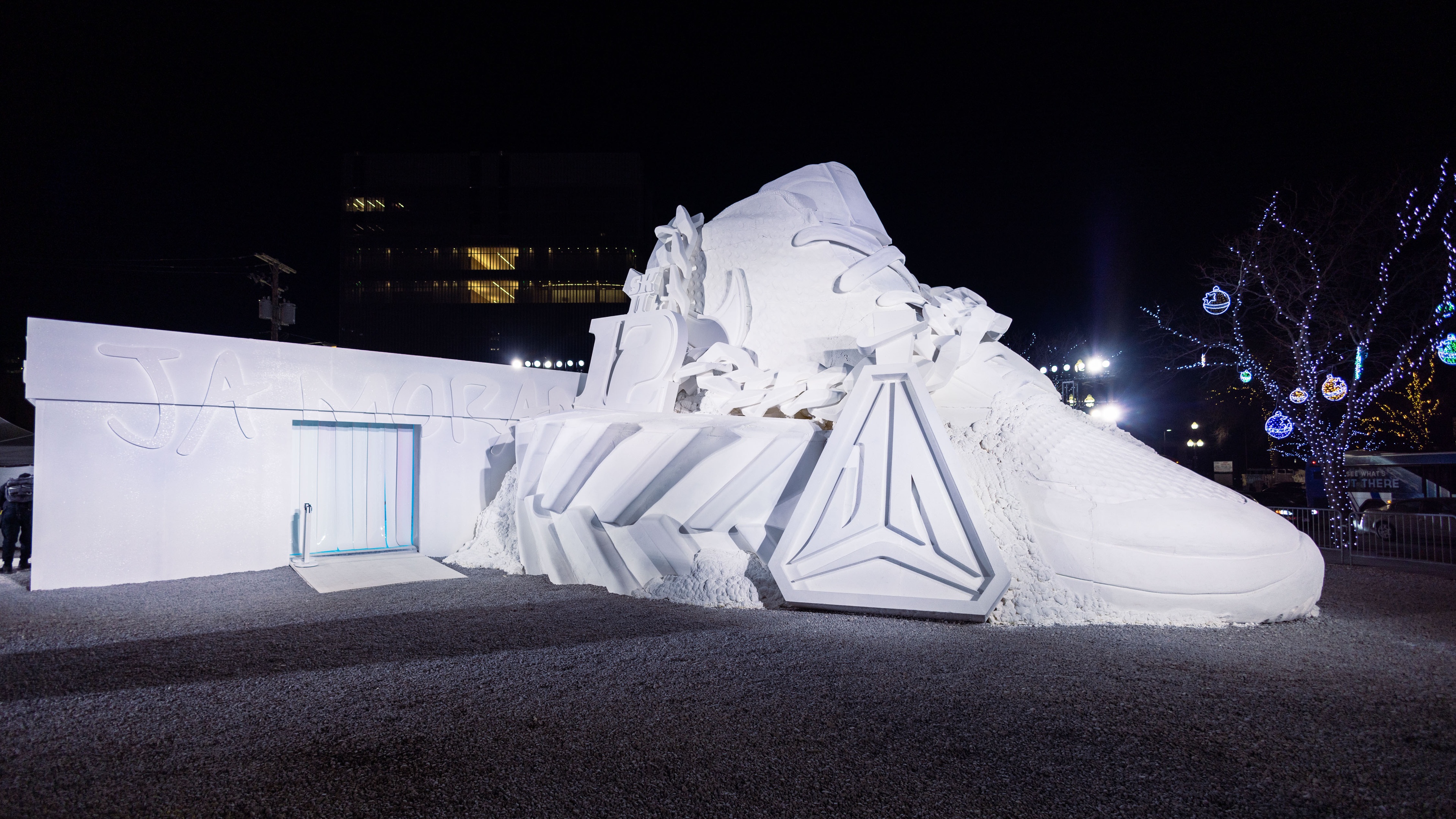 Giant white Nike sneaker sculpture and shoe box at night
