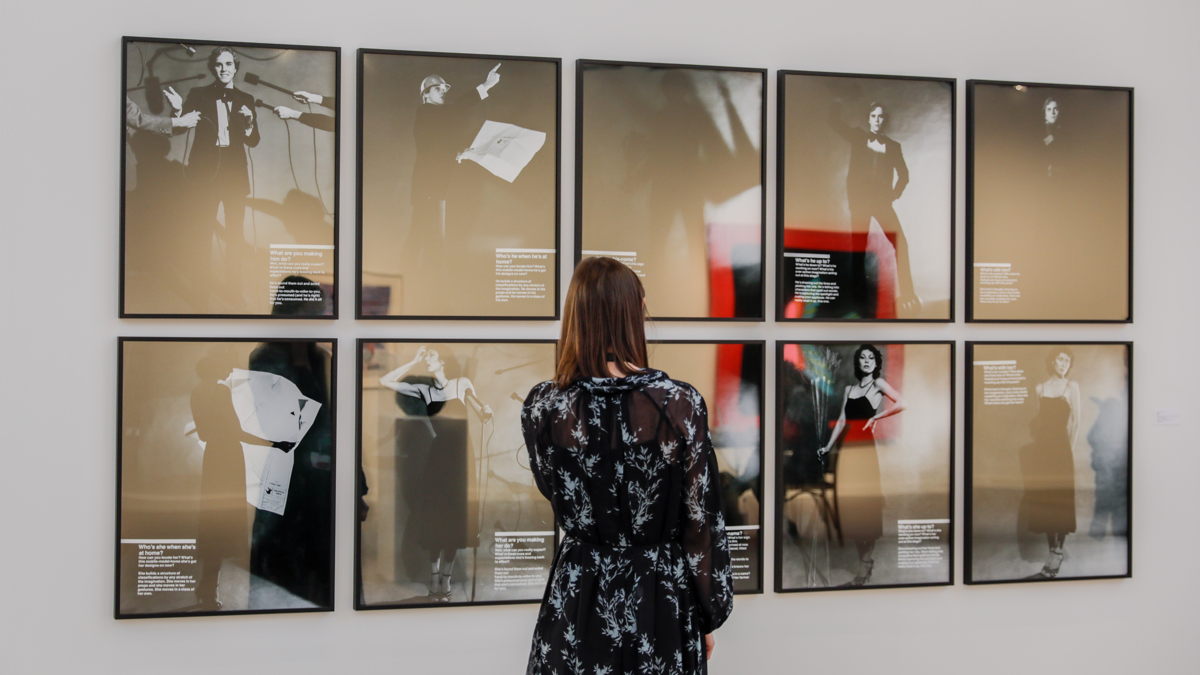 Woman standing in front of several wall mounted photographs