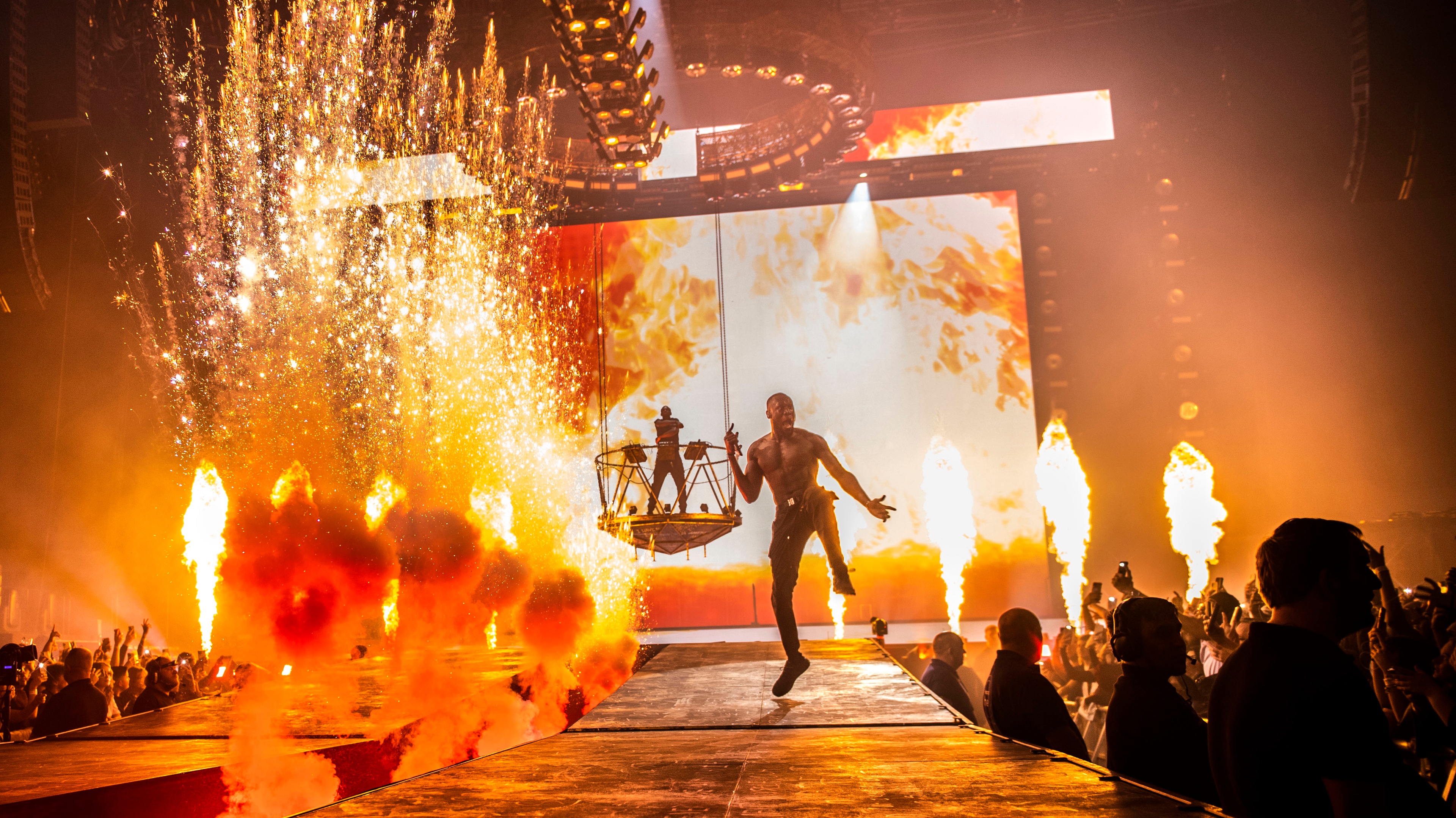 Rapper Stormzy performing on runway with pyro elements and fire LED backdrop