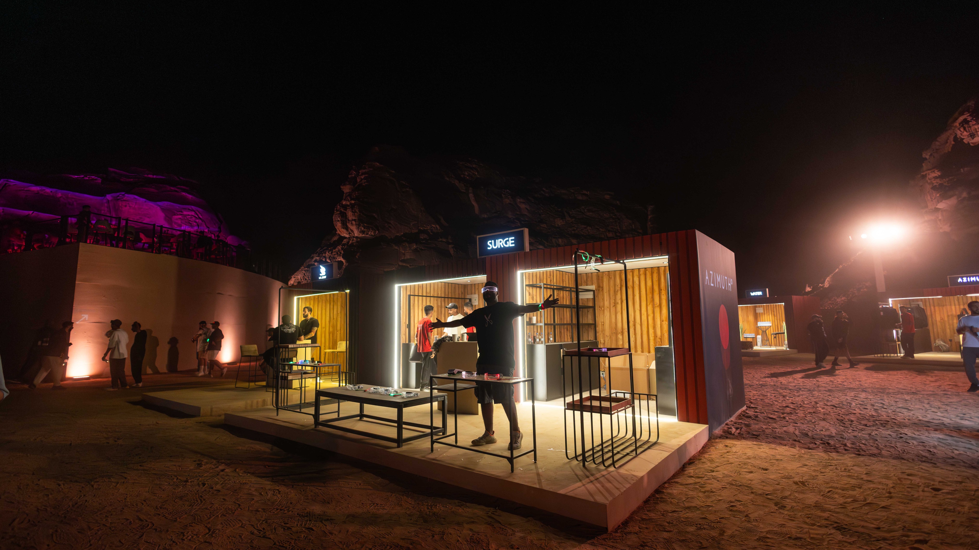 Person stood with arms stretched out in front of pop up structure on sand