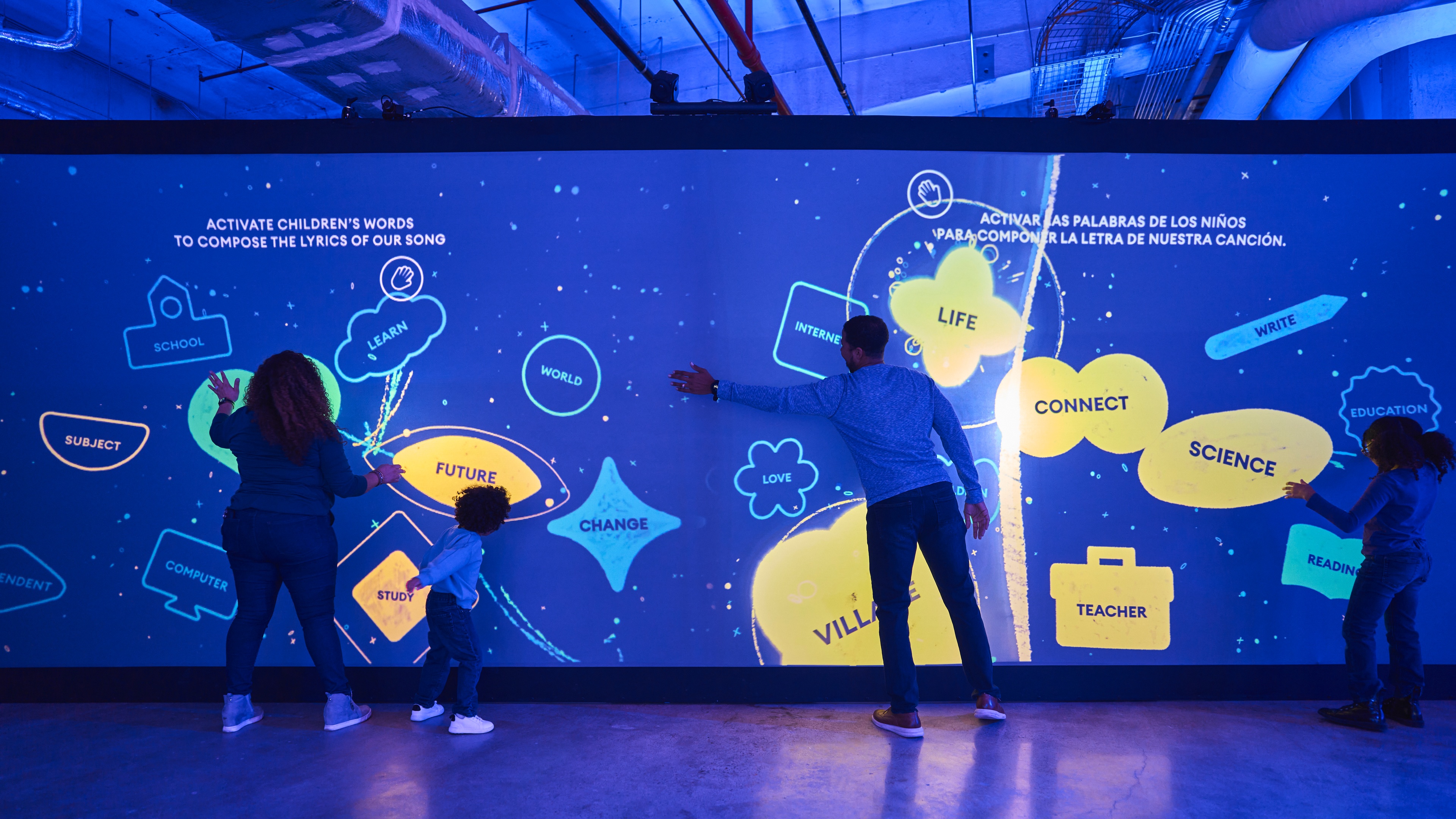 Blue LED wall with interactive graphics and families interacting