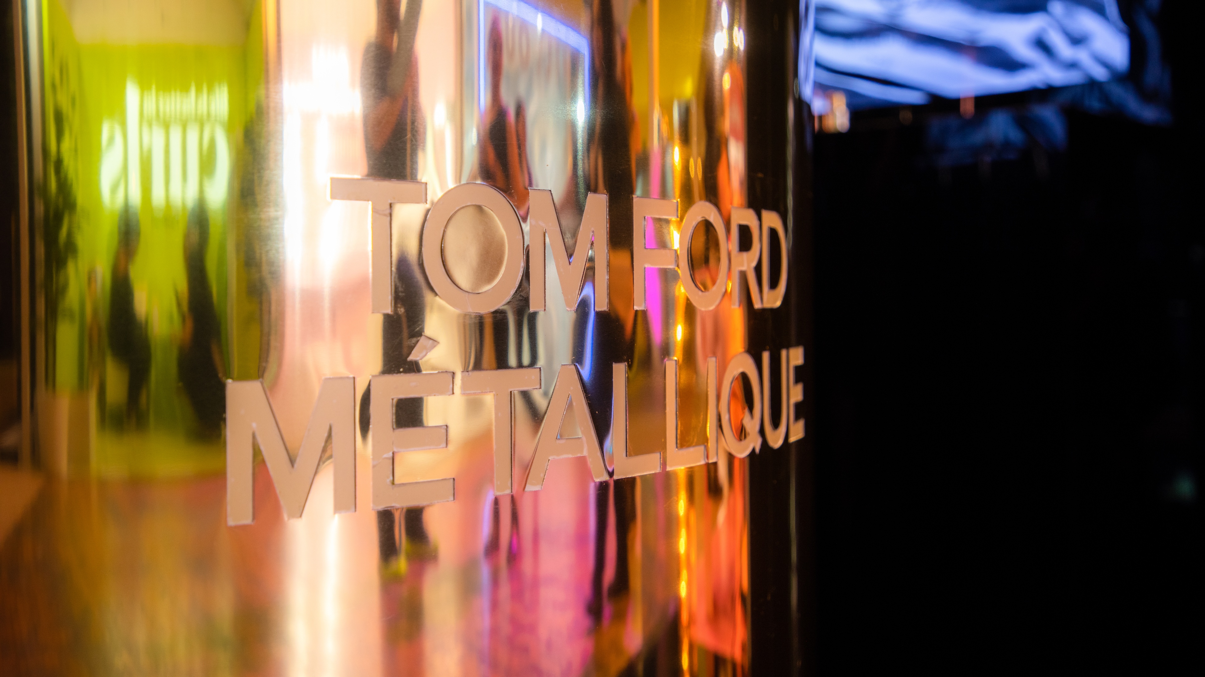 Close up shot of gold metallic replica saying Tom Ford Metallique