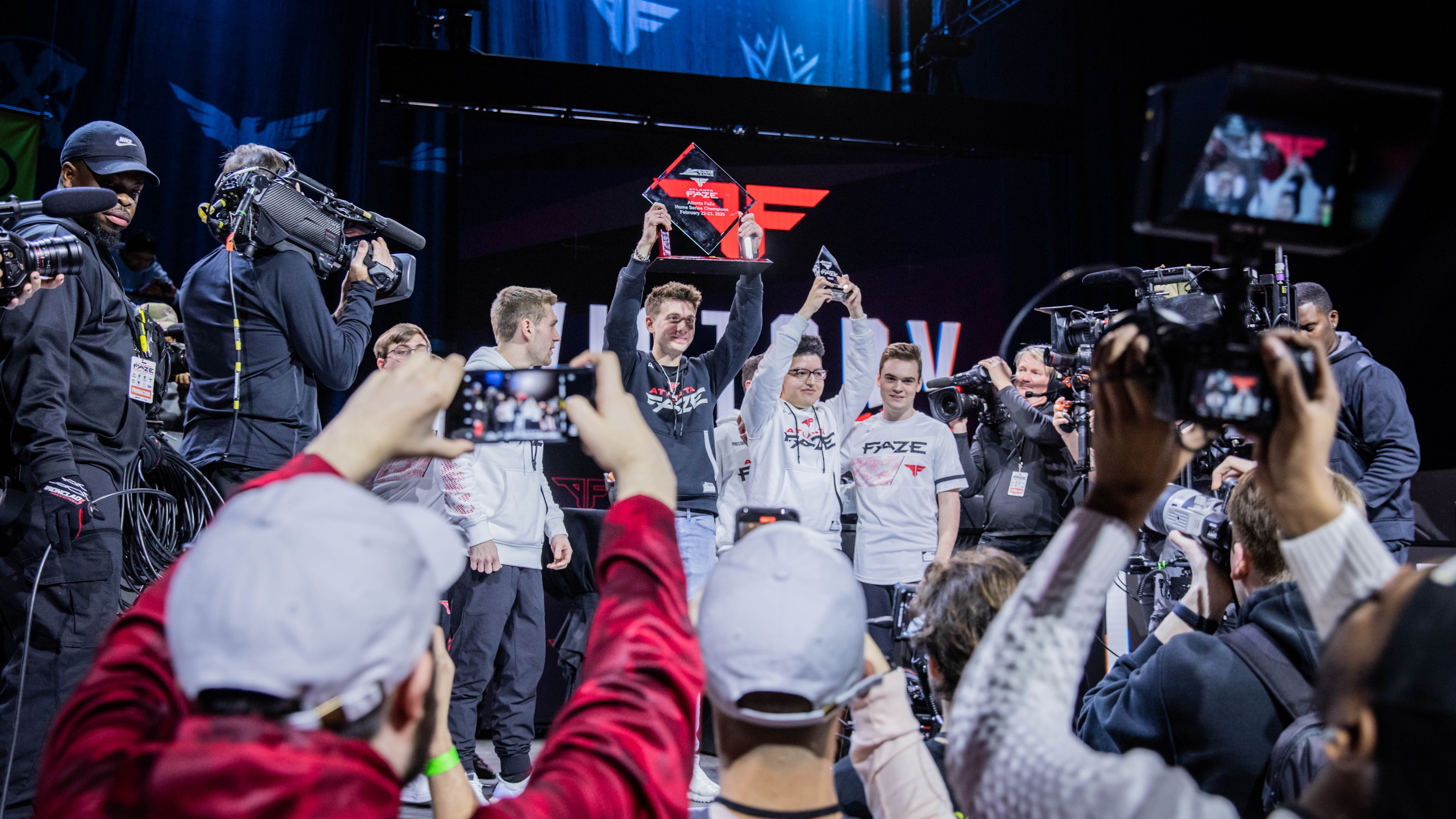 Atlanta FaZe team holding up trophy on stage and smiling