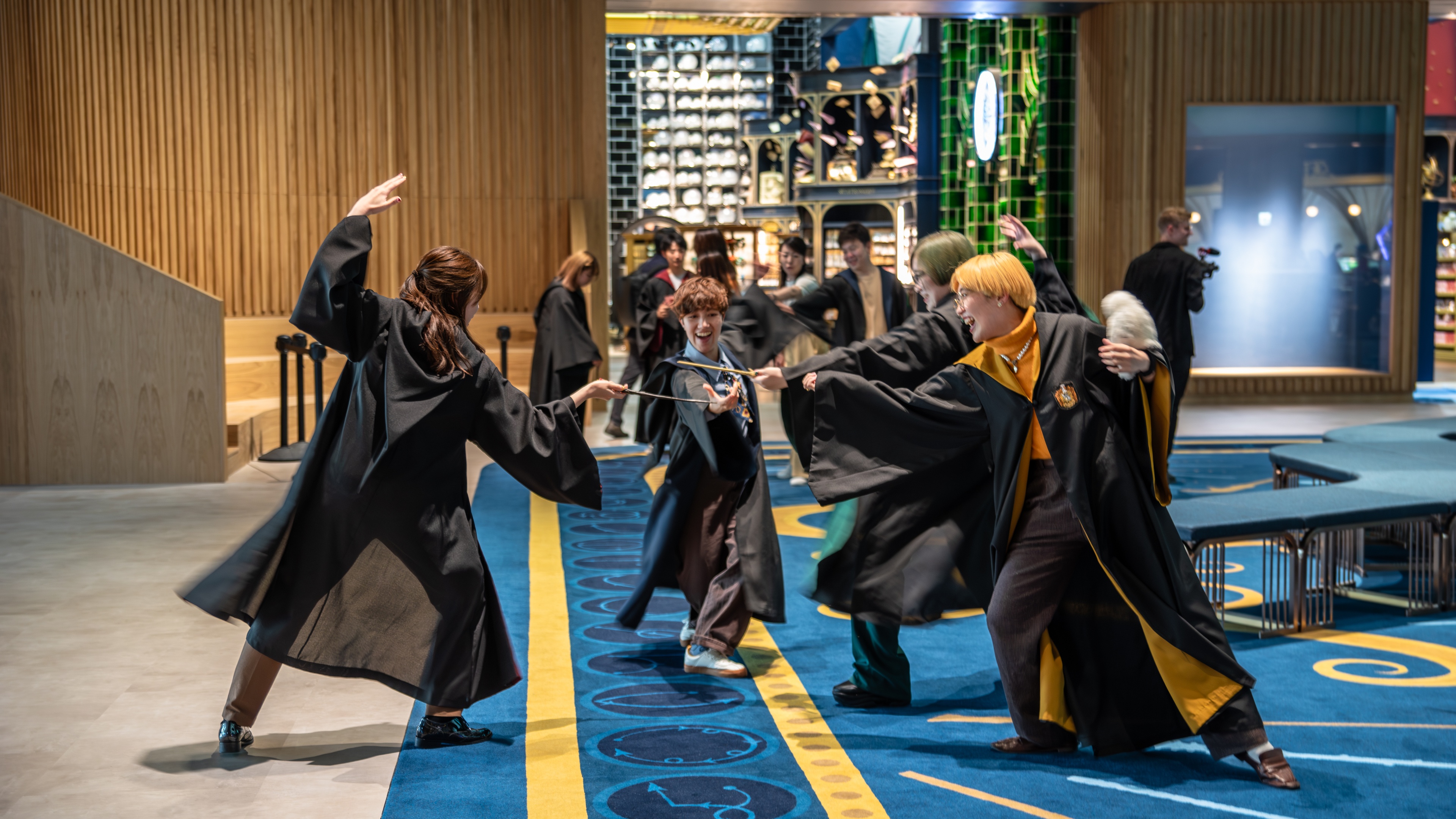 Children cosplay Harry Potter with wands in large entrance lobby