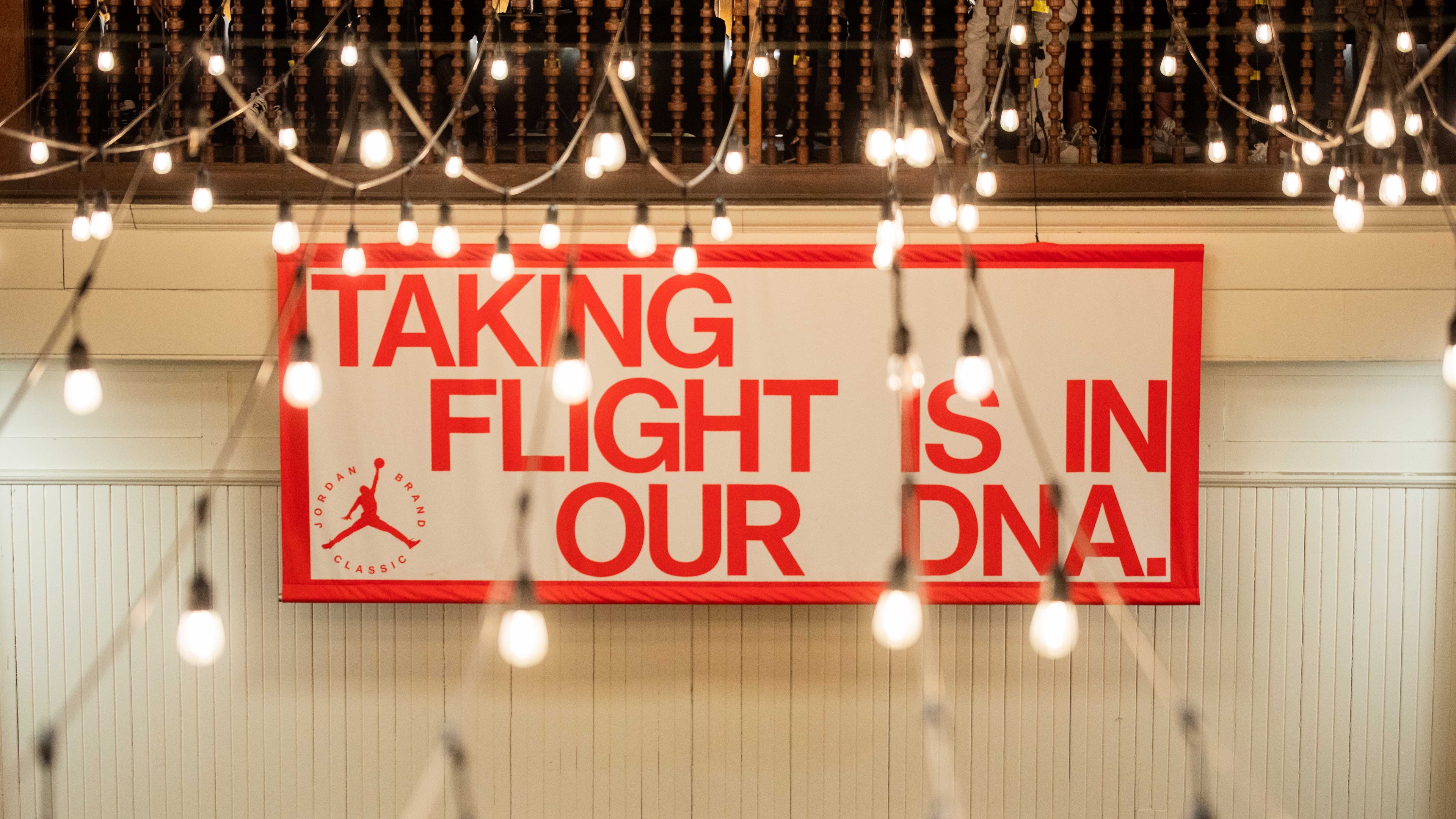 White and red banner with "taking flight is in our DNA" on it