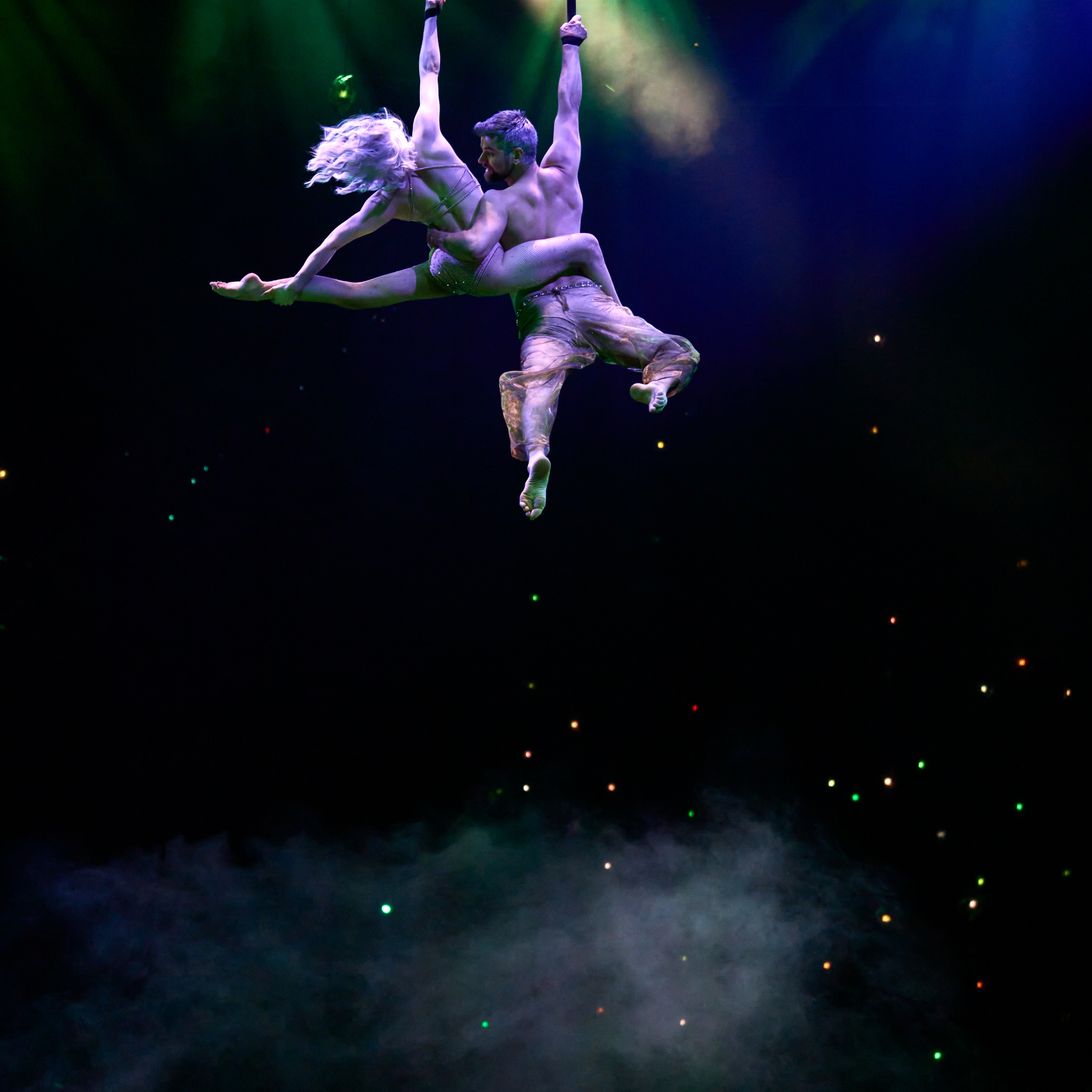 Awakening performers flying above stage in white costume