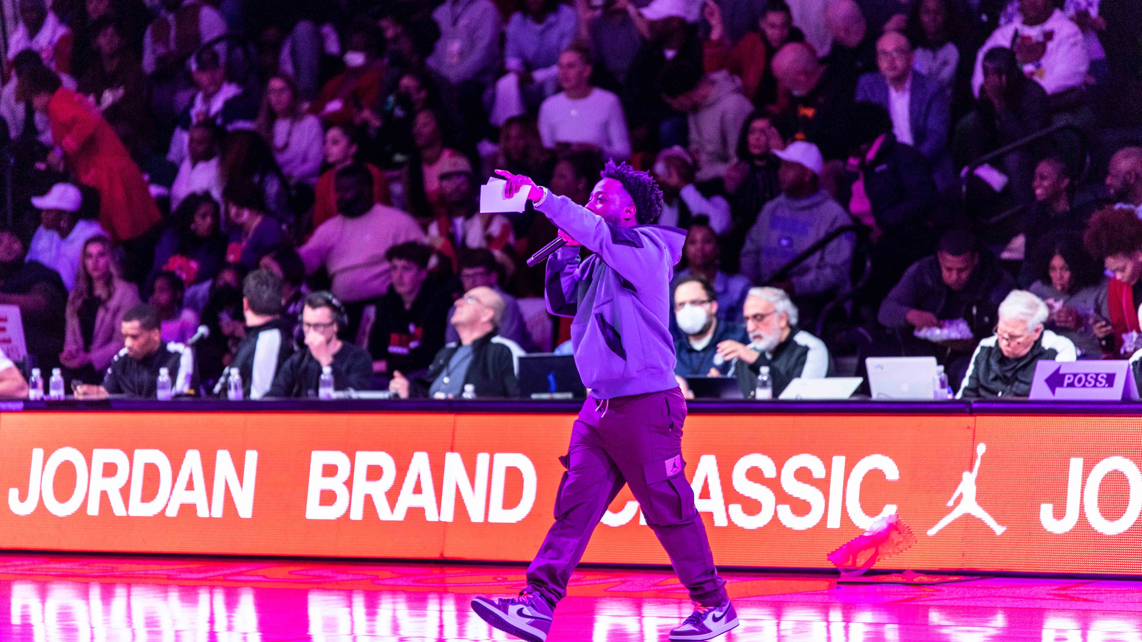MC on basketball court pointing at crowd