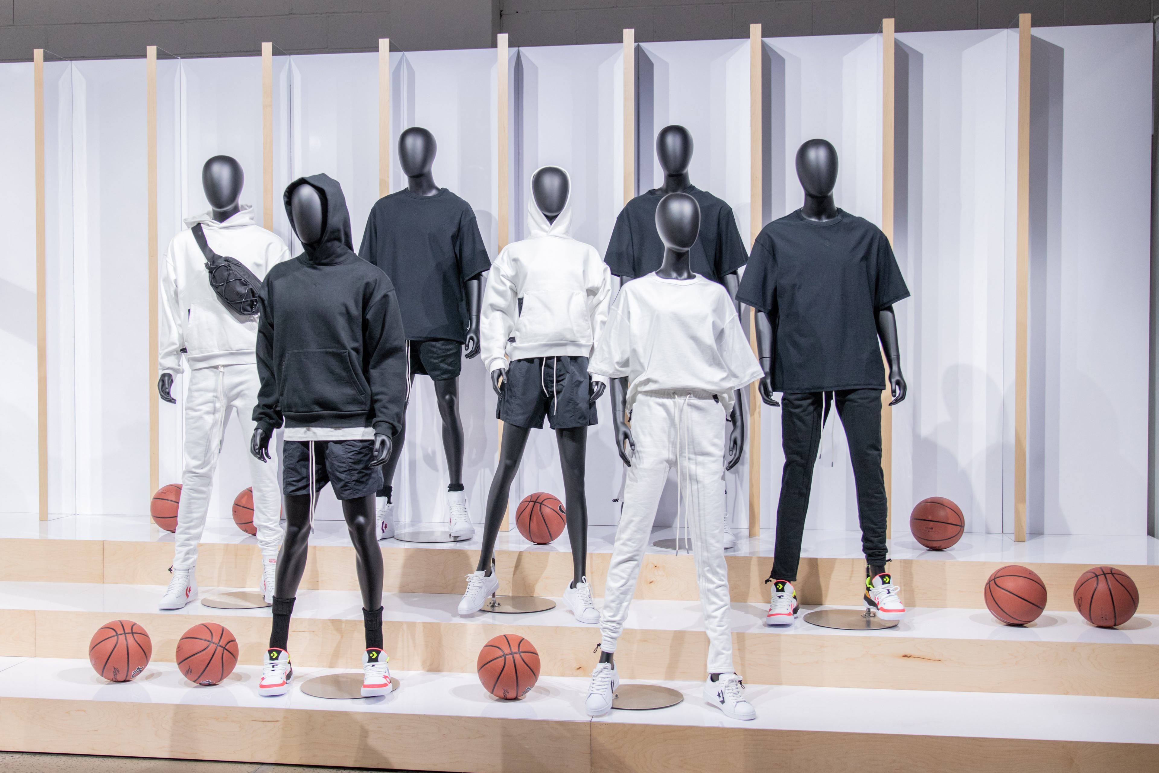 Mannequins with black and white clothing surrounding by basketballs