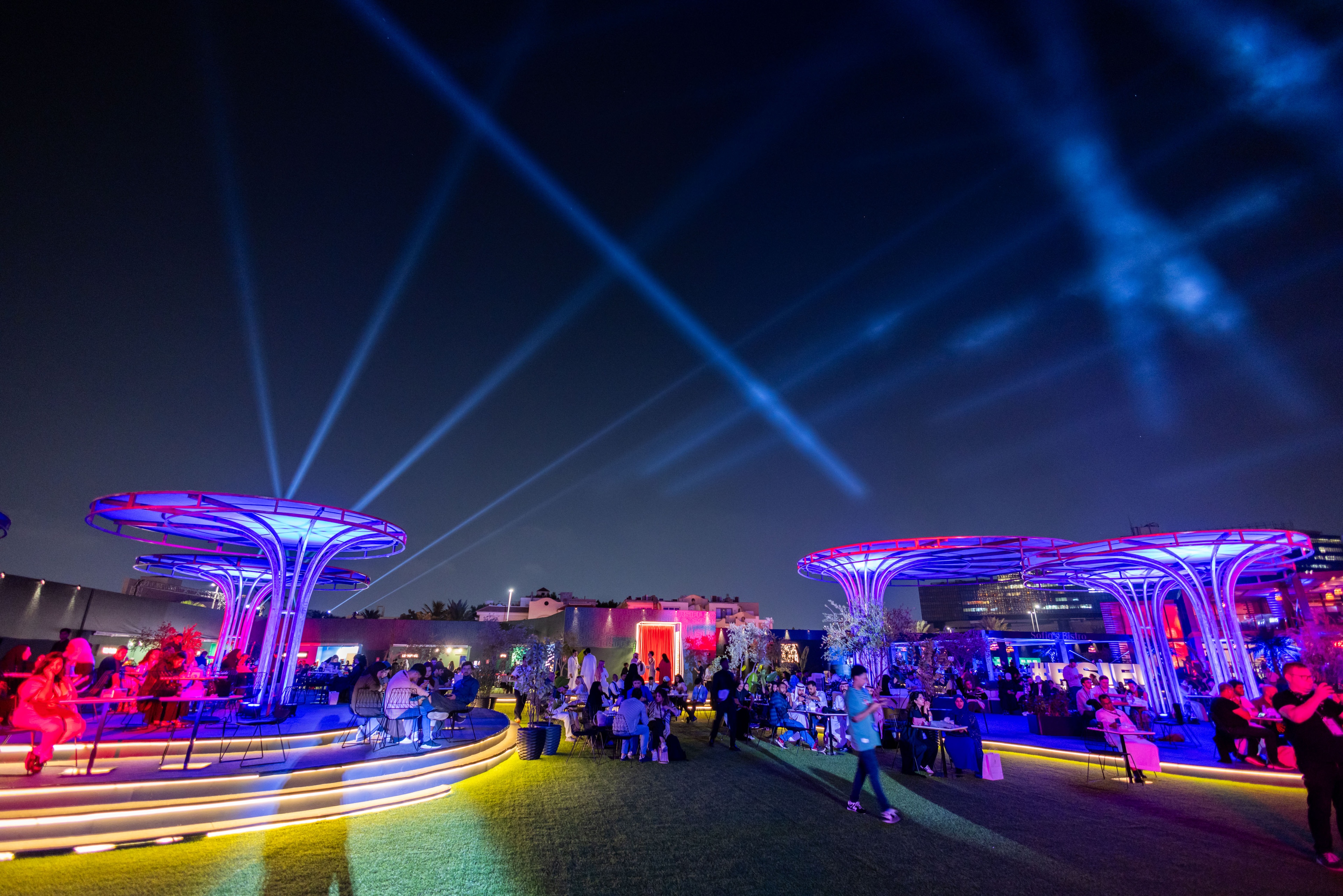Outdoor guest experience at night lit up blue and red