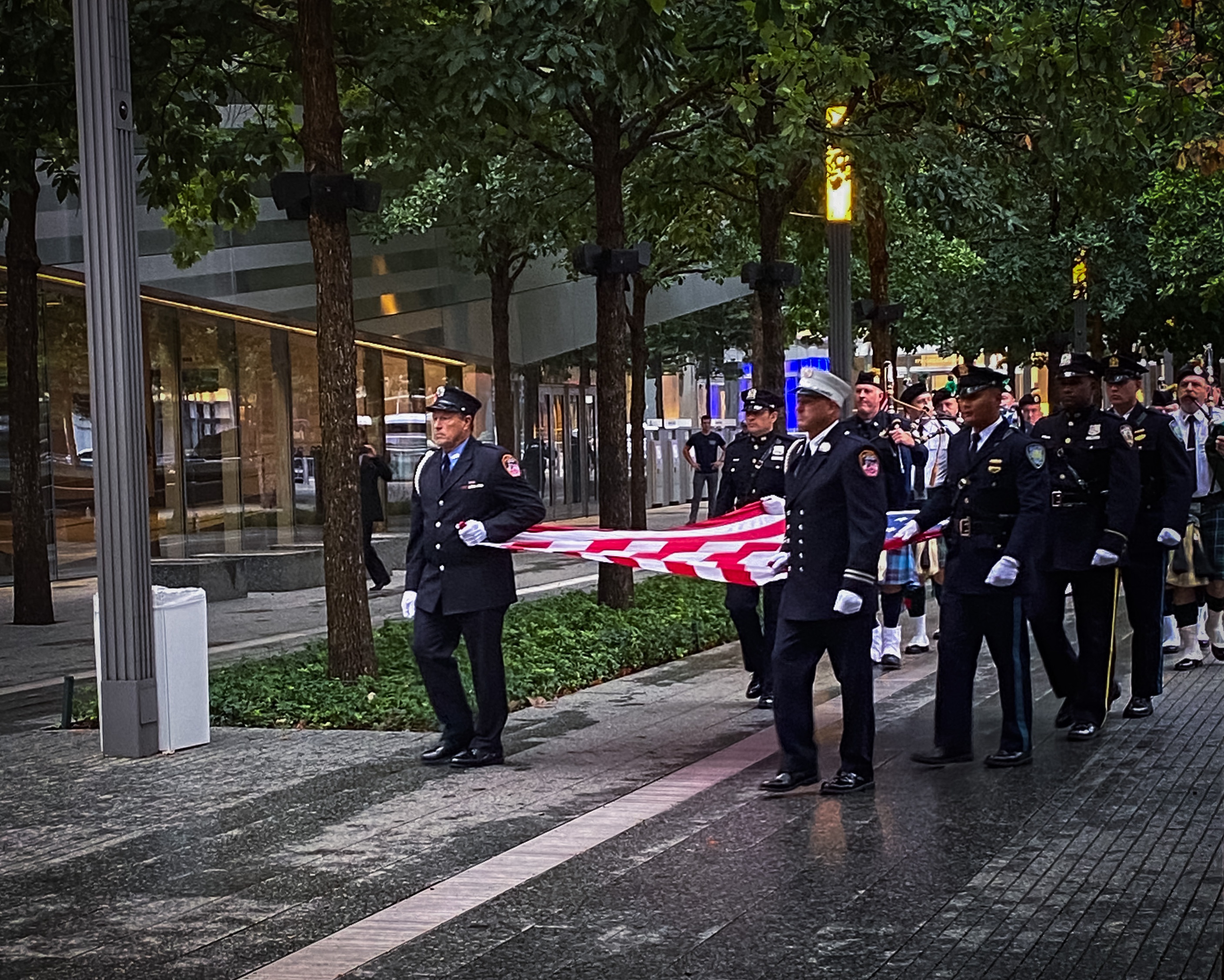 Military figures carrying American flag through new york street