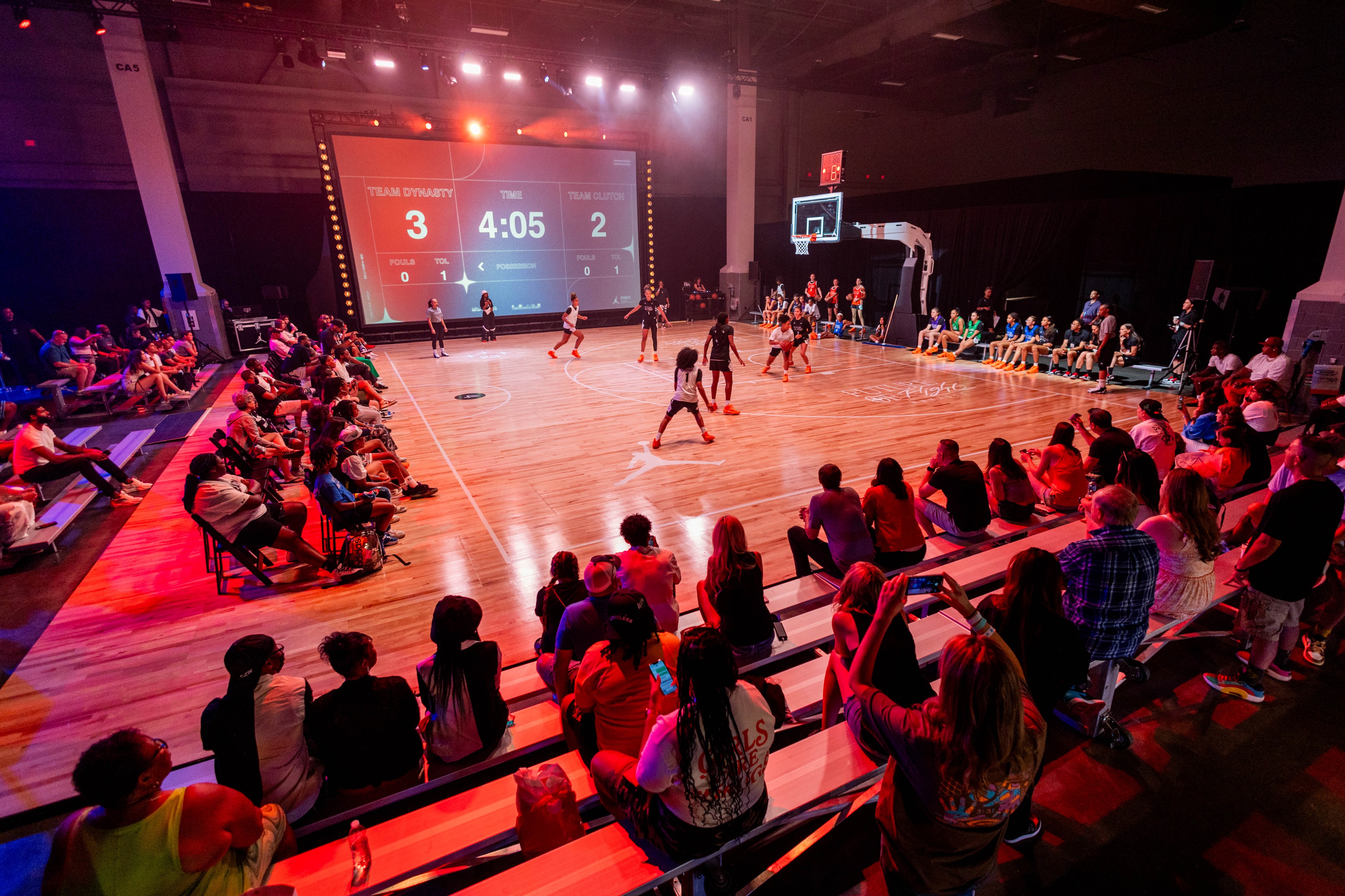 Nike Jordan Brand WNBA All-Star Weekend Las Vegas spectators seating on benches watching a basket ball game in action, players are young females