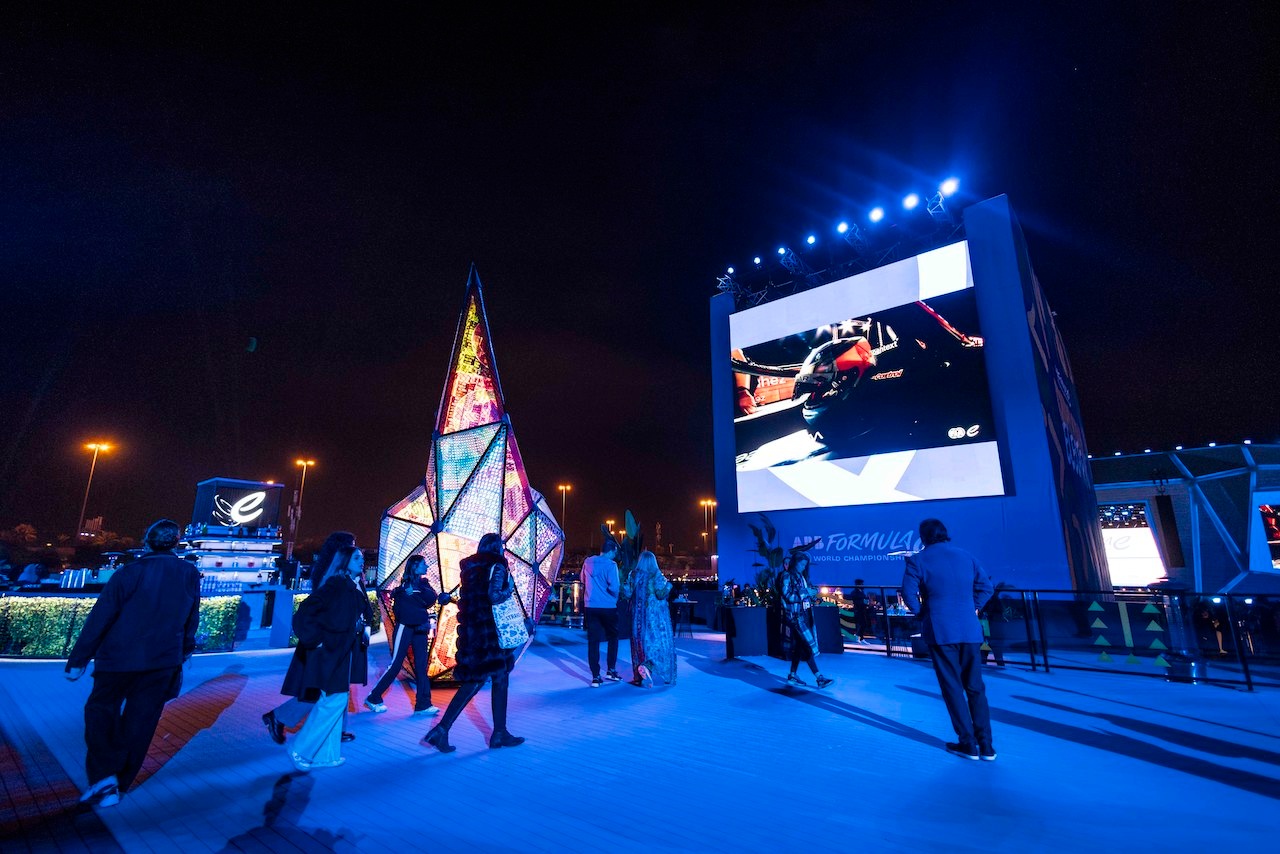 Guests standing in front of large screen lit up blue