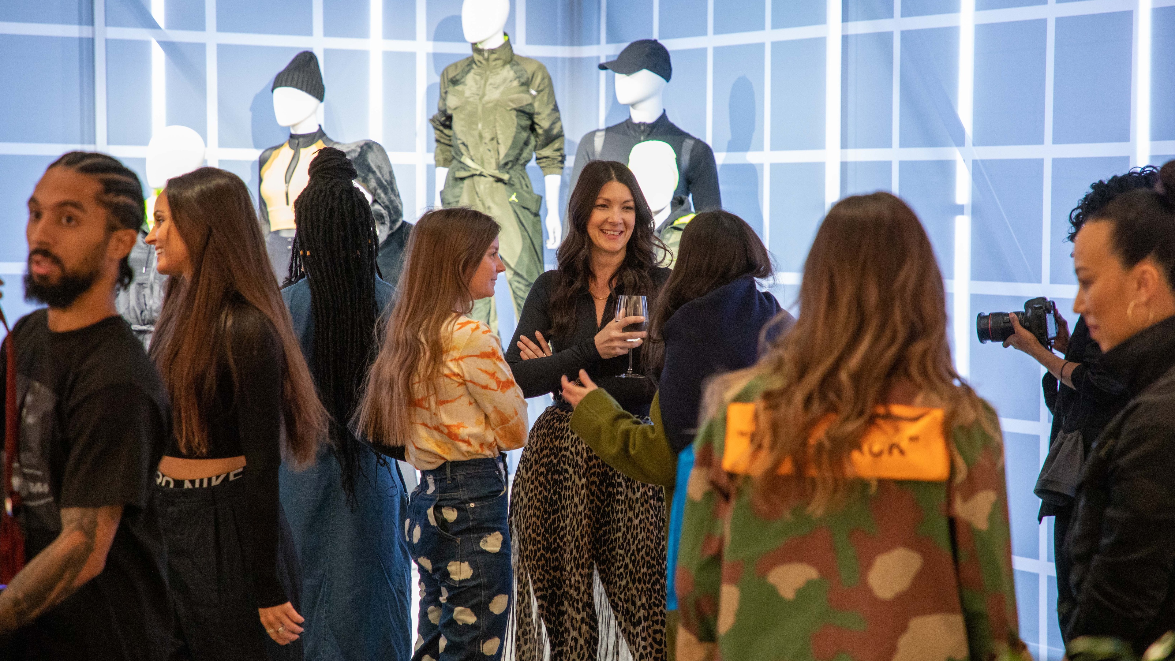Women talking and smiling in front of mannequins