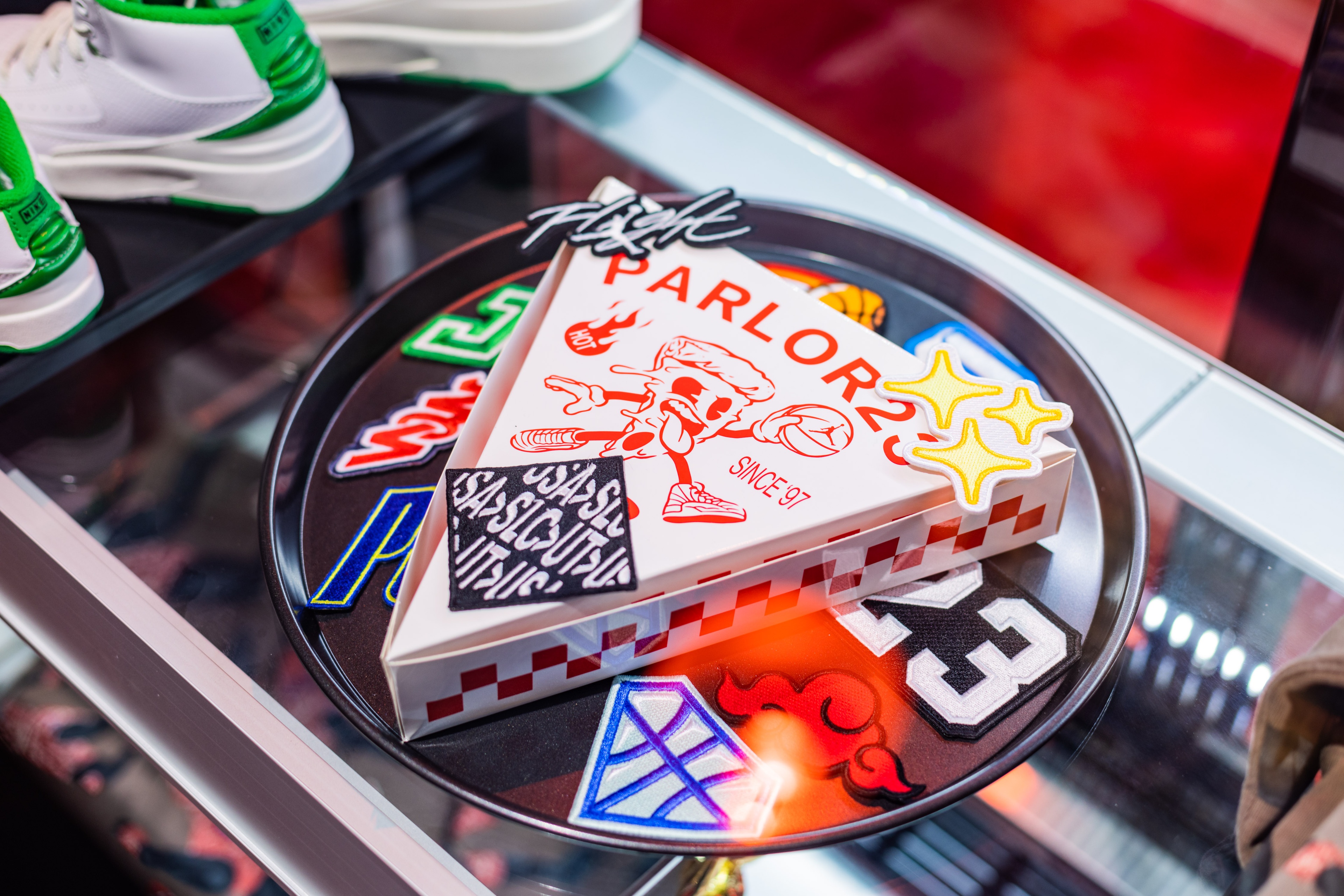 Jordan Parlor23 pizza box on serving plate with stickers all over it